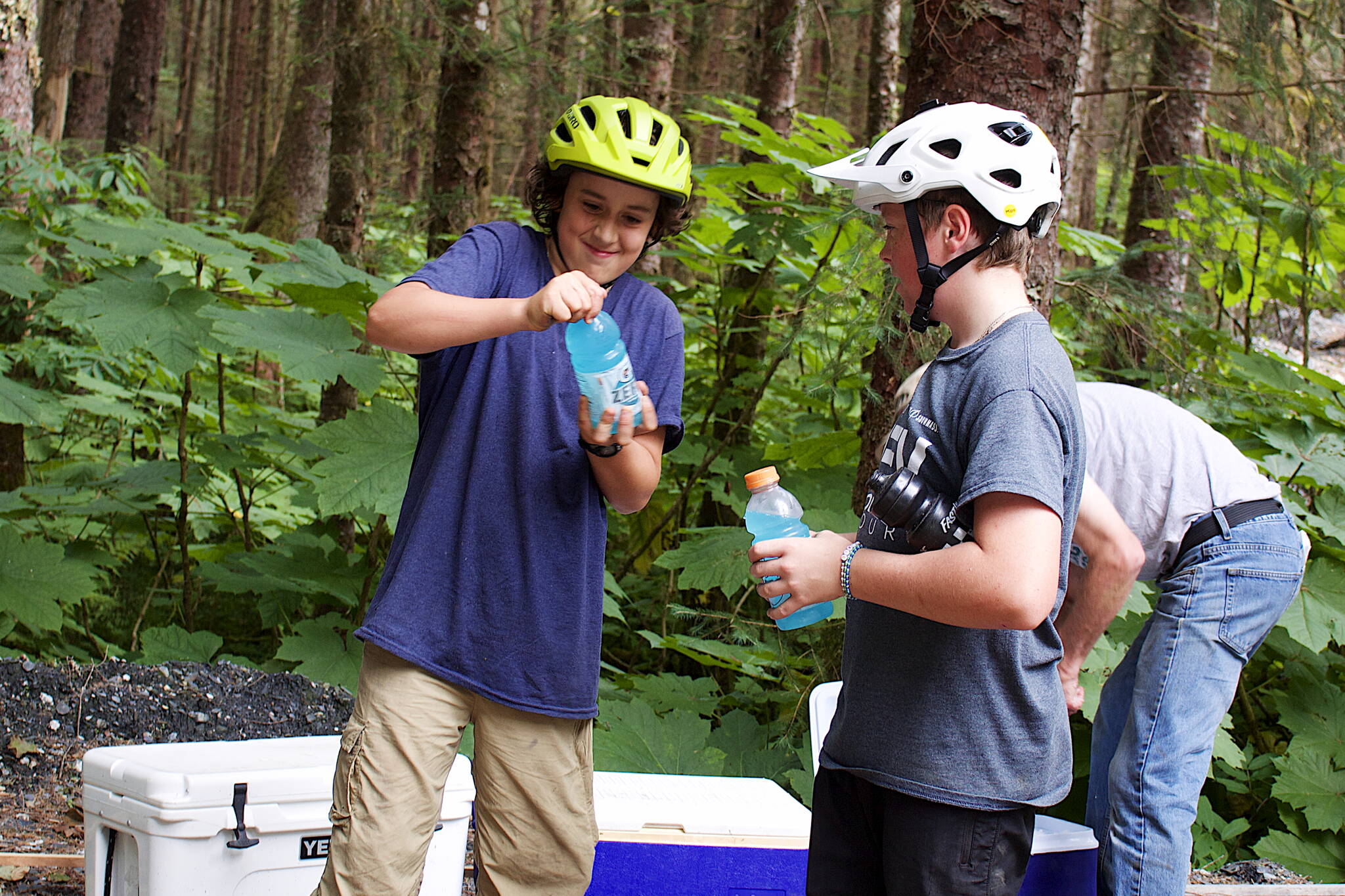 Bay White (left) and Reid Graham, both 13, take a break while volunteering to work on the nearly completed Thunder Mountain Bike Park on Saturday. Both said they are experienced riders who frequent other mountain bike trails in Juneau. (Mark Sabbatini / Juneau Empire)