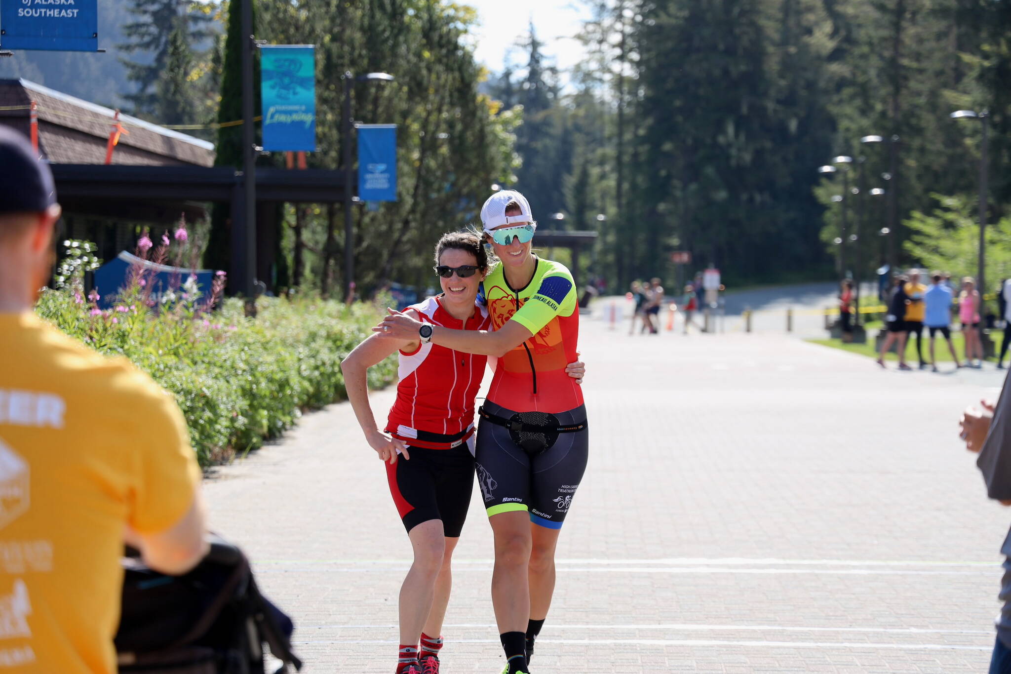 April Rezendes (left) and Jenna Wiersma (right) embrace at the finish line after completing the Aukeman Triathlon at the University of Alaska Southeast campus on Sunday. (Clarise Larson / Juneau Empire)