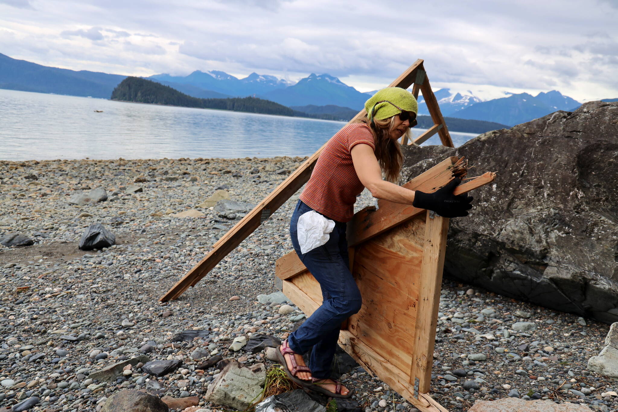 Ava Christ, who is visiting Juneau for two weeks, picks up pieces of large debris on a beach on North Douglas on Monday afternoon. Christ, who wanted to get involved with helping the community after hearing about the “tragedy” of the flooding, said she filled about four bags of trash in just a few hours of cleanup. (Clarise Larson / Juneau Empire)