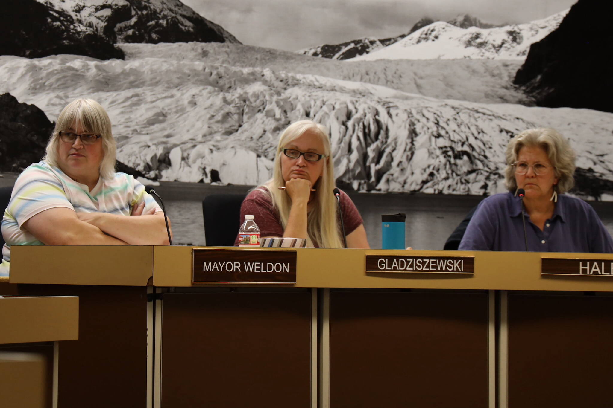 City and Borough of Juneau Mayor Beth Weldon (far left), Deputy Mayor Maria Gladziszewski (middle) and Assembly member Michelle Bonnet Hale listen during a special Assembly meeting Monday night where members OK’d a resolution to seek state and federal funding following record flooding over the weekend. (Clarise Larson / Juneau Empire)