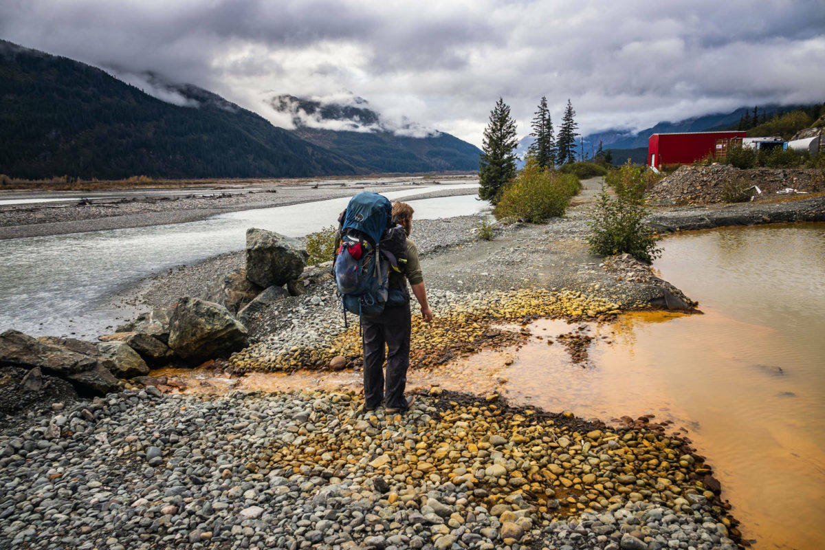 Bjorn Dihle stands in front of acid mine drainage at British Columbia’s Tulsequah Chief mine, which has been abandoned and leaching acid mine drainage into the transboundary Taku River watershed for more than 65 years. The Taku, a wild salmon river, flows into Alaska and empties into the ocean just south of Juneau. (Photo by Chris Miller/csmphotos.com)