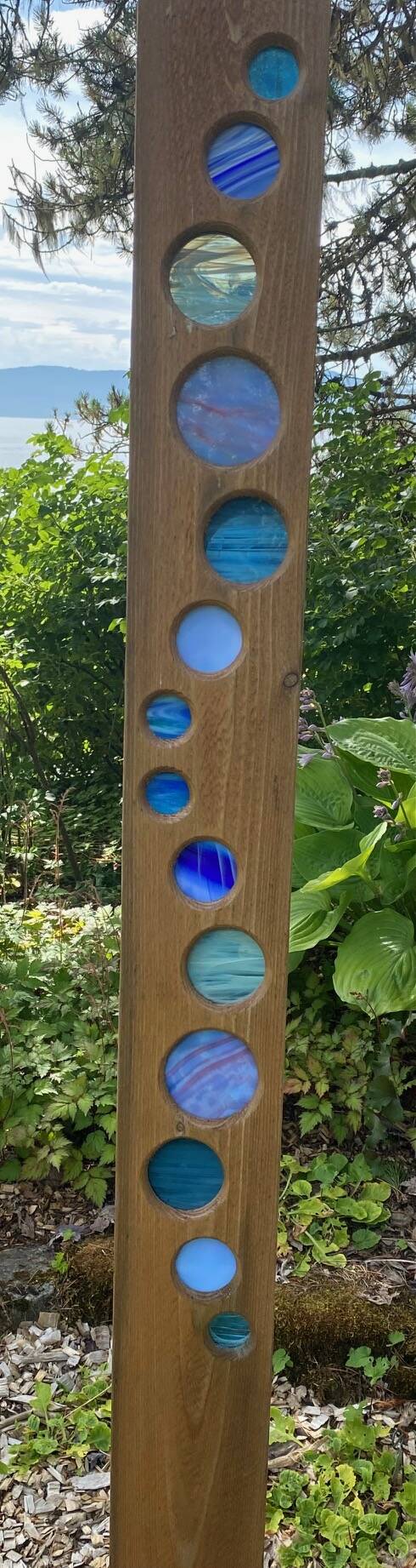 Circular shades of blue wend their way down a wooden post at the Arboretum seen on Aug. 5. (Photo by Denise Carroll)