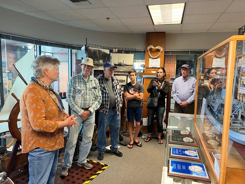 Visitors, some waiting to board the Columbia state ferry, look at a historic display at the ferry terminal in Bellingham, Washington, in July. (Meredith Jordan / Juneau Empire)