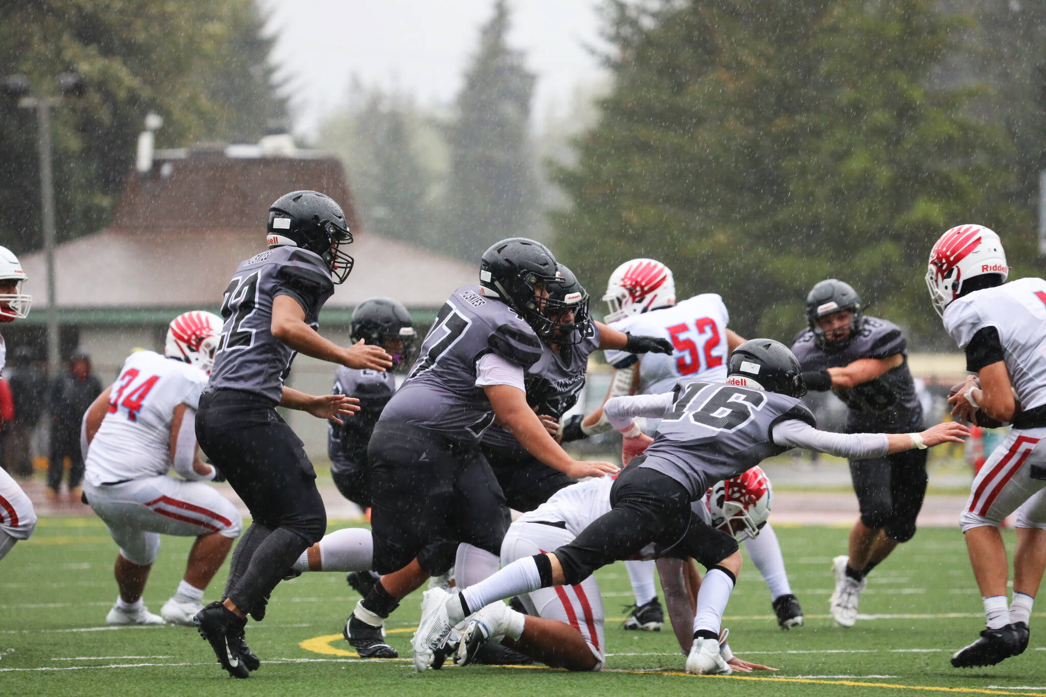 Players collide during the second quarter of the Juneau Huskies’ season opener against East Anchorage Saturday afternoon at Adair-Kennedy Memorial Park. (Clarise Larson / Juneau Empire)