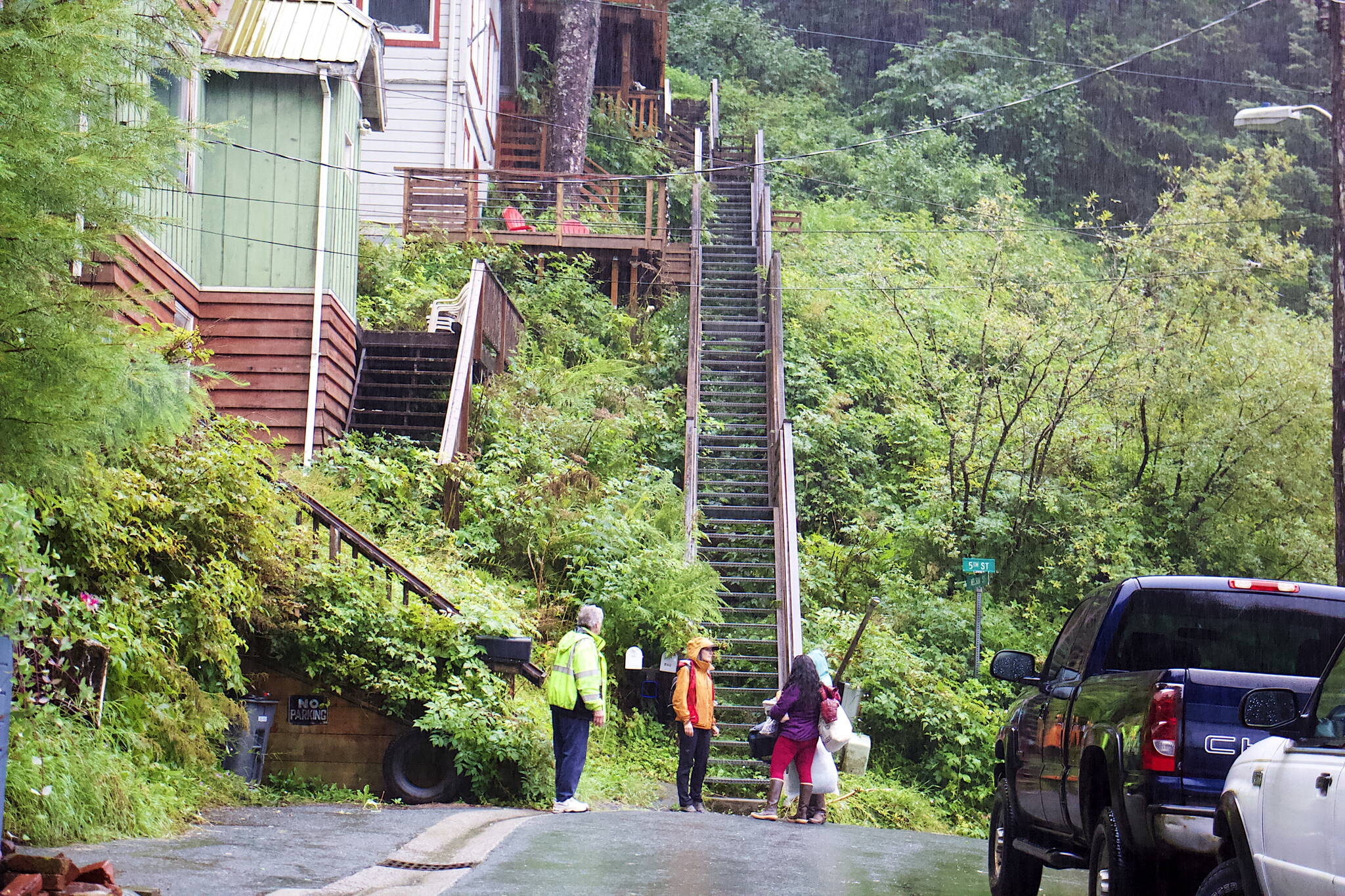 An American Red Cross worker (in orange) advises people evacuating belongings from a house on Nelson Street following a small landslide Saturday evening. City officials ordered the evacuation of homes near the slide, and issued a notice asking people to stay away from the landslide area and for people in high-slope areas to be aware of landslide risks due to heavy rain. (Mark Sabbatini / Juneau Empire)