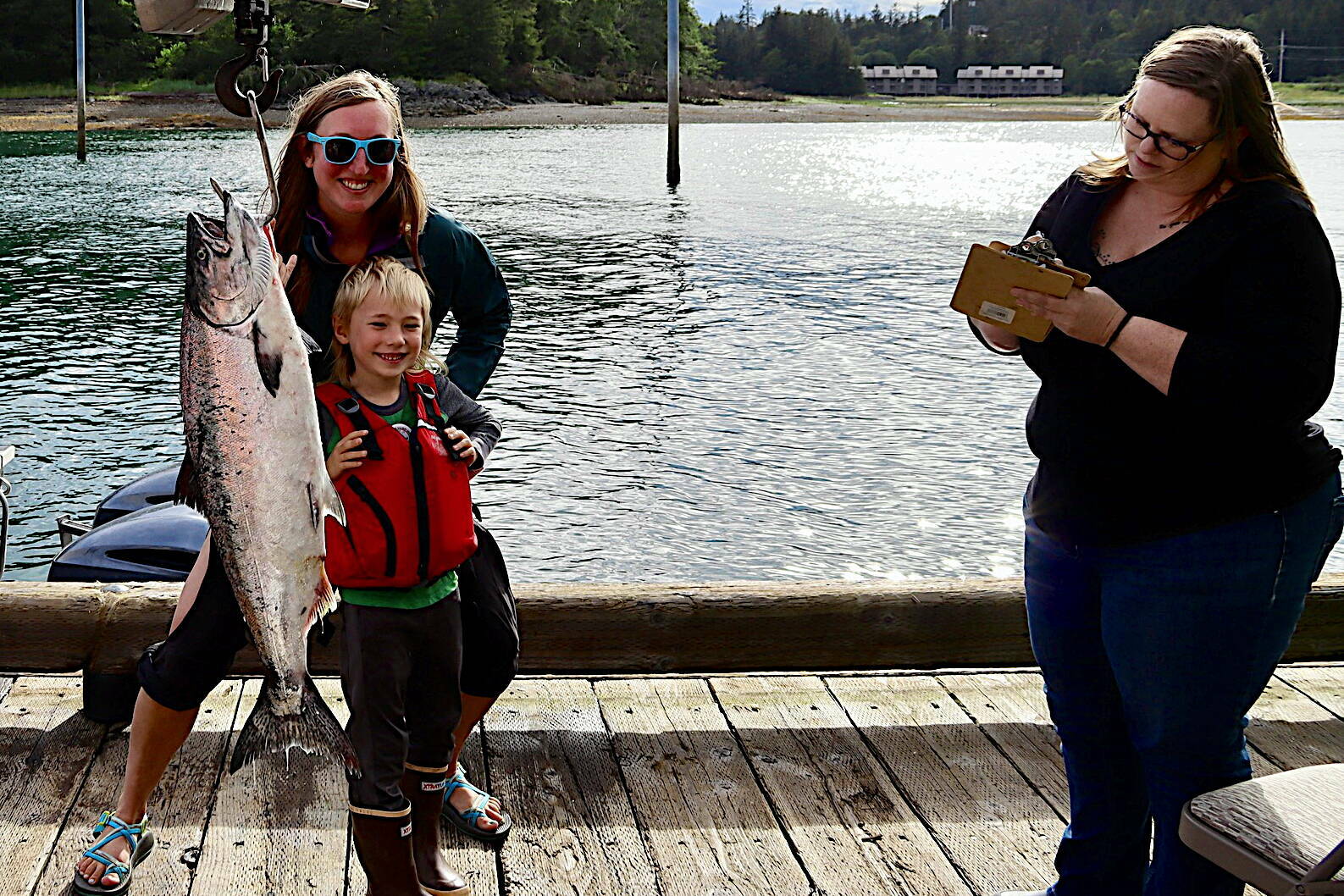 Jackie Ebert, 37, and her son William Oliver Dryer, 6, stand behind a fish he caught on Friday, the first day the 77th annual Golden North Salmon Derby, at the Auke Nu Cove weigh station. A few minutes earlier Ebert turned in a 14.2-pound fish, narrowly edging out a 14 pounder that was the heaviest at that point in the day. (Meredith Jordan / Juneau Empire)