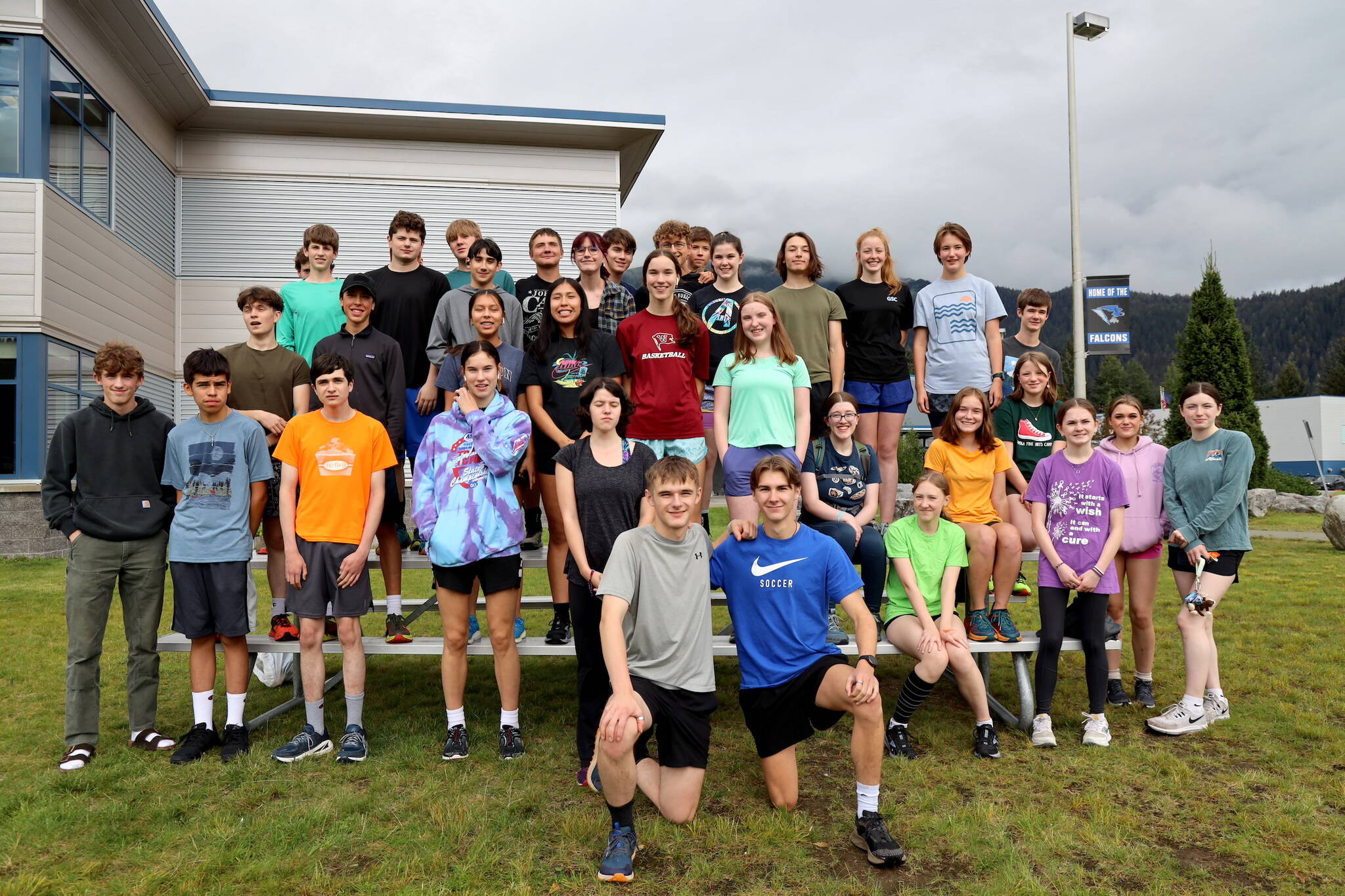 The Thunder Mountain High School cross-country team pose for a photo before their practice began outside of the high school Thursday evening. (Clarise Larson / Juneau Empire)