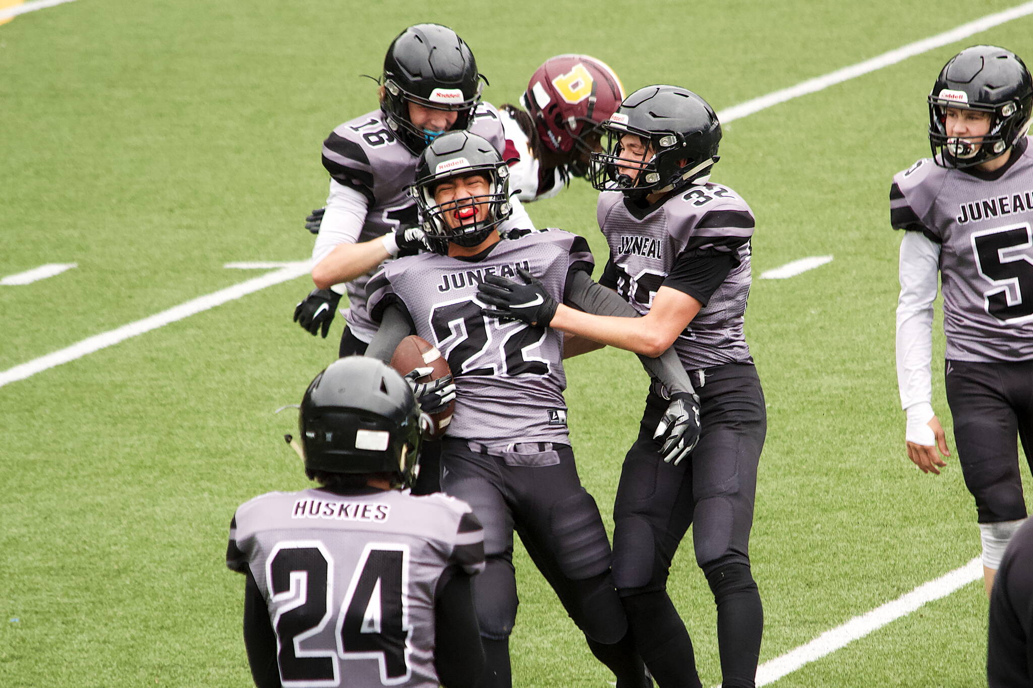 Anthony Garcia (22) celebrates with Juneau Huskies teammates after intercepting a pass with less than two minutes left in the third quarter against the Dimond High School Lynx on Saturday at Adair-Kennedy Field. The interception sparked a rapid 19-point rally by the Huskies, who were trailing 32-14 at the time, as they took a 33-32 lead with about 10 minutes in the fourth quarter before going on to lose by a final score of 40-33. (Mark Sabbatini / Juneau Empire)