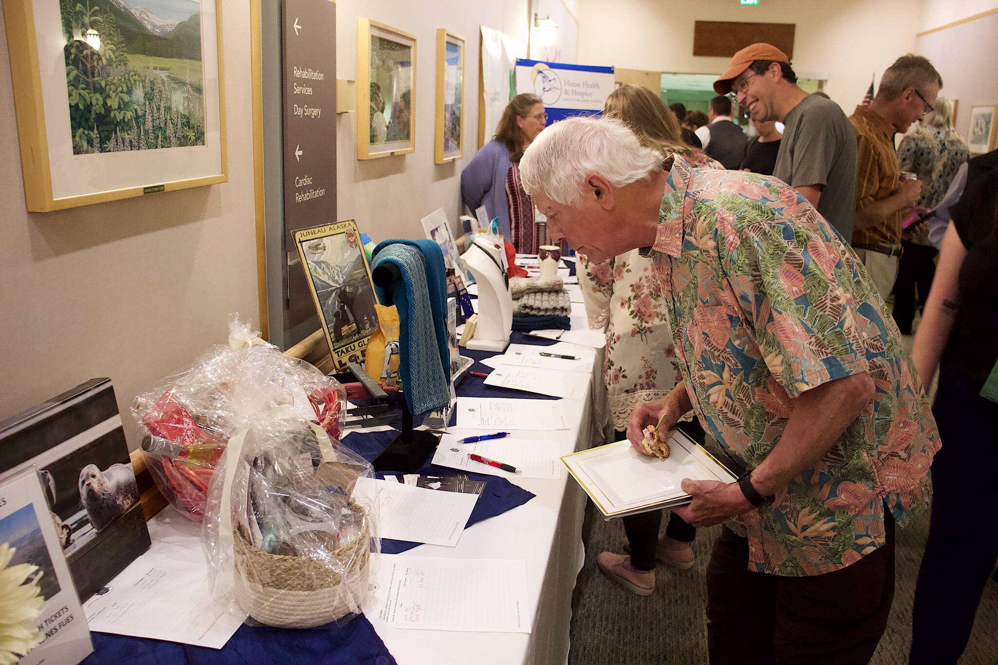 Mark Sabbatini / Juneau Empire
Sam Trivette, a Juneau resident since 1954, examines items at a silent auction during Bartlett Regional Hospital celebratory launch of hospice and home care services Thursday.