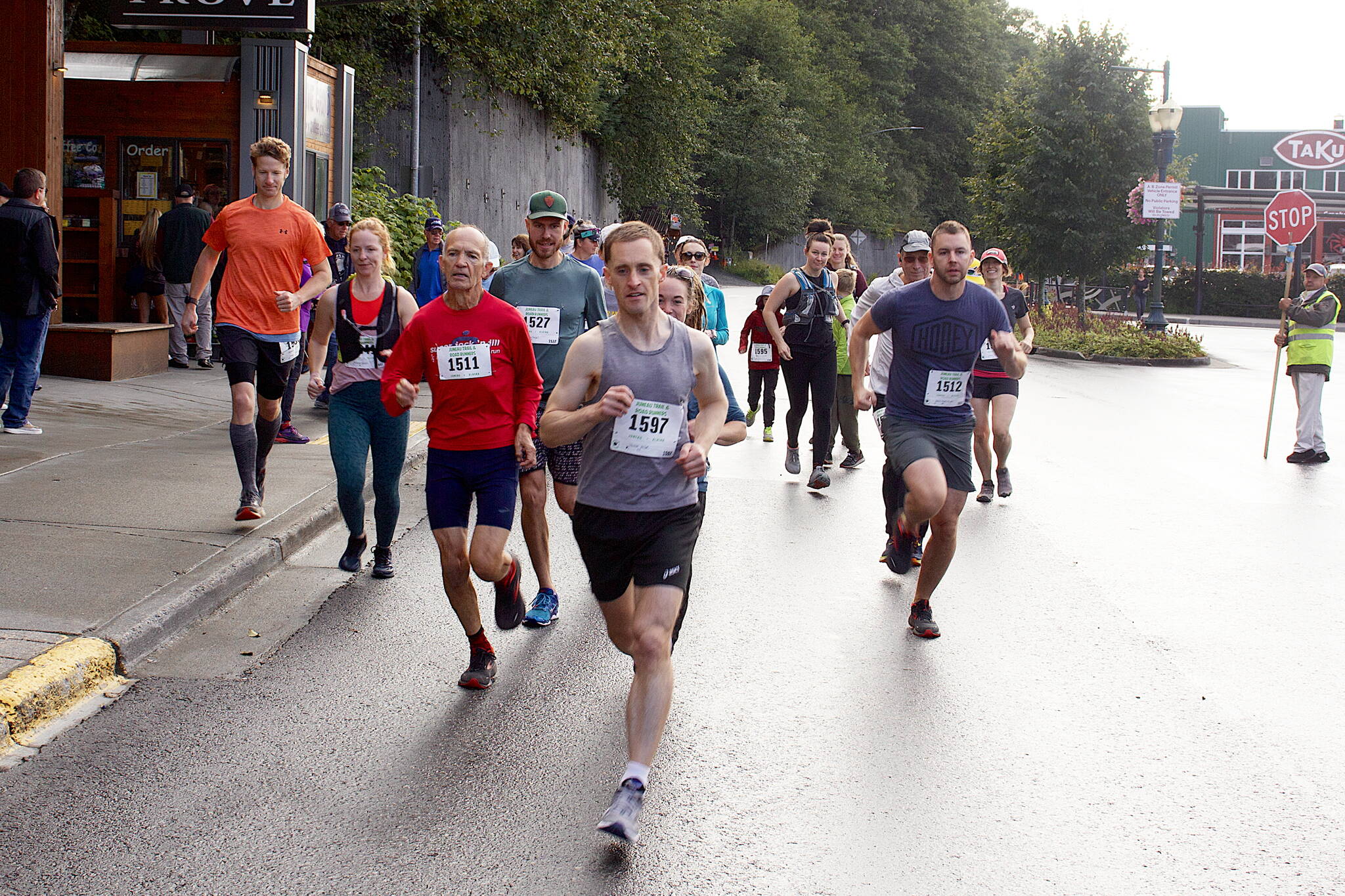 Twenty-two runners take off from the starting line of the Goldbelt Tram-Mount Roberts Run at the base of the tram on Saturday morning. (Mark Sabbatini / Juneau Empire)