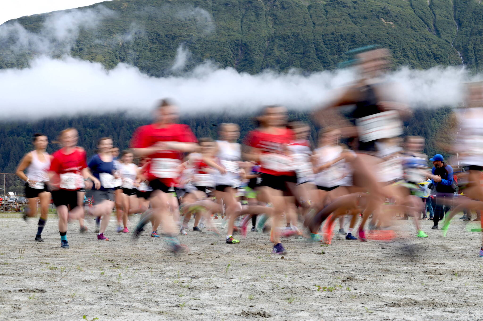 A blur of high school girls sprint after the starting gun fires on Saturday morning during the Sayeik Invitational on Douglas. (Clarise Larson / Juneau Empire)