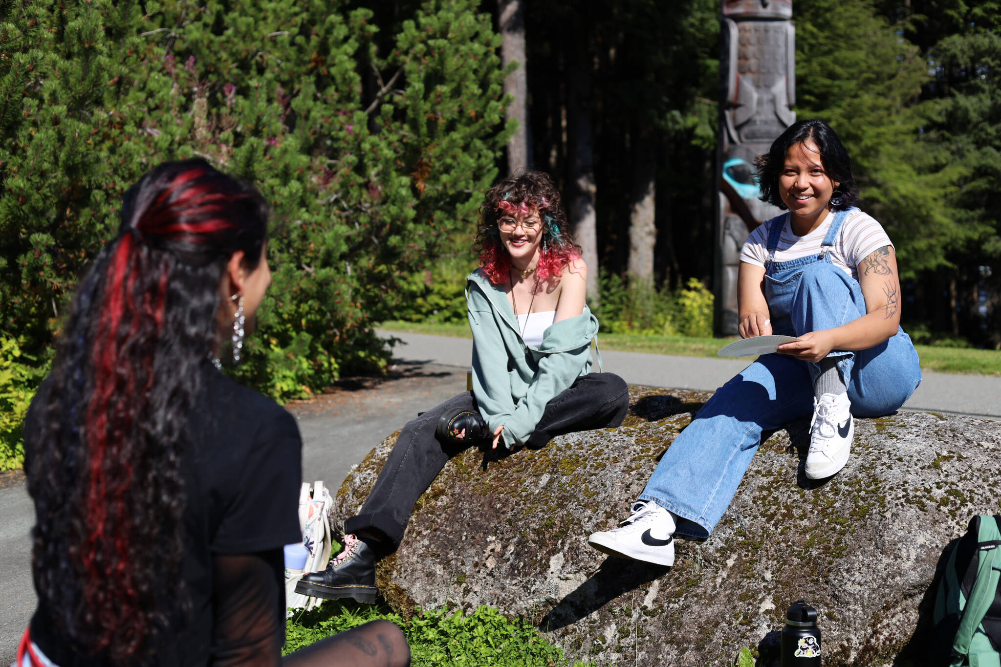 From left to right, students Kelby Randall, KC Abad and Sage Chavez smile as they sit outside during a lunch break Monday afternoon at the University of Alaska Southeast campus in Juneau on the first day of the 2023 fall semester. (Clarise Larson / Juneau Empire)