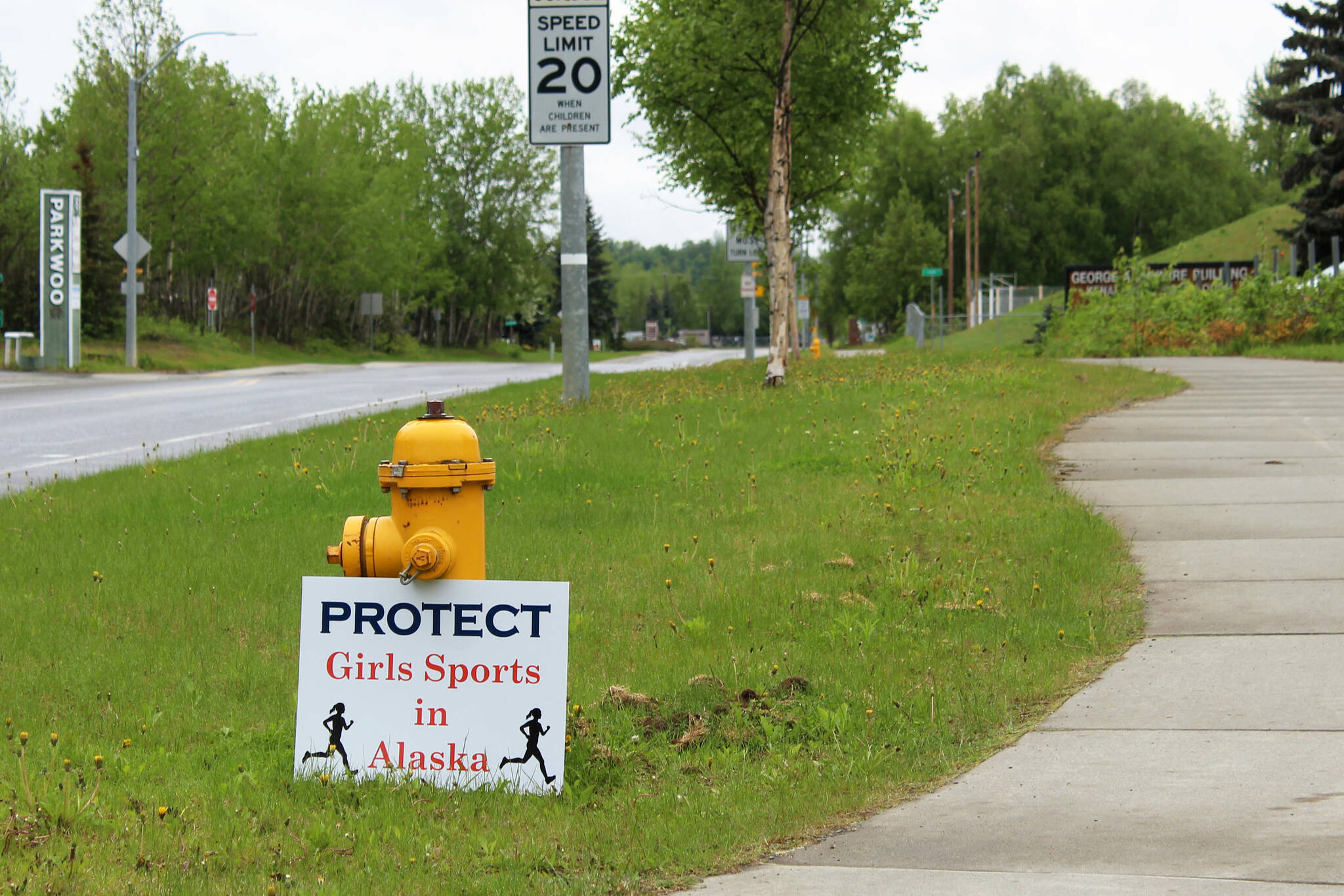 A sign opposing the participation of trans girls in girls sports is propped against a fire hydrant outside of the George A. Navarre Admin Building on Thursday, June 8, 2023 in Soldotna, Alaska. The Alaska Board of Education met in the building to discuss a resolution that would ban trans girls from girls high school sports. (Ashlyn O’Hara/Peninsula Clarion)