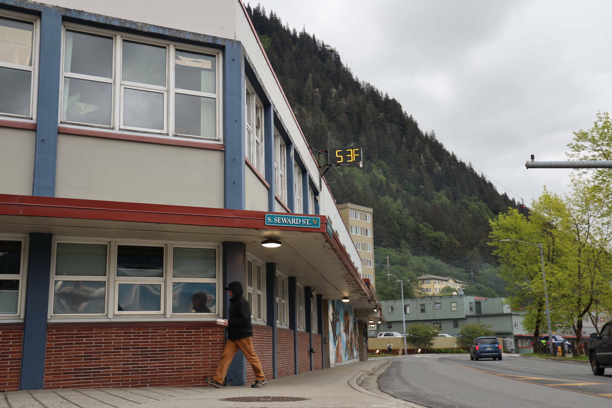 Cars and people move past the City and Borough of Juneau’s current City Hall downtown on June 5. (Clarise Larson / Juneau Empire File)