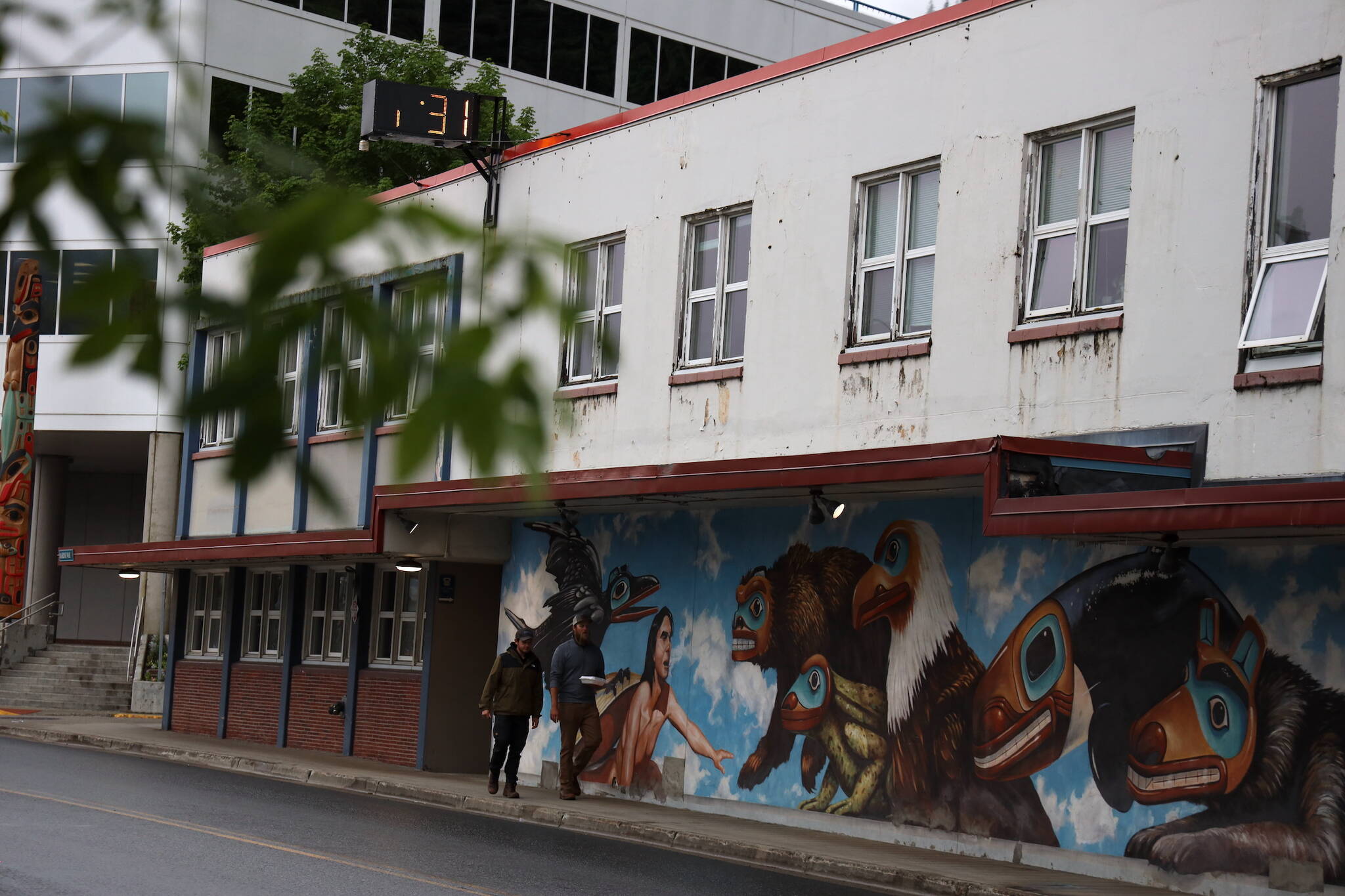 People walk past the current City Hall downtown in late June. (Clarise Larson / Juneau Empire File)