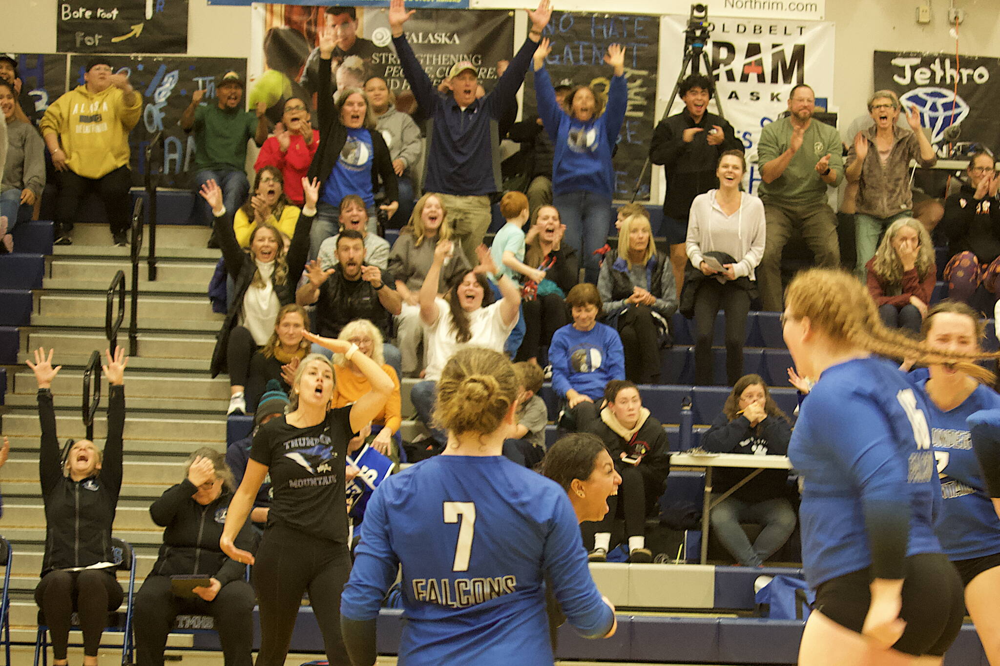 Thunder Mountain High School players and spectators celebrate as the Falcons score the winning point to prevail in a five-set series over Ketchikan High School on Saturday night. (Mark Sabbatini / Juneau Empire)