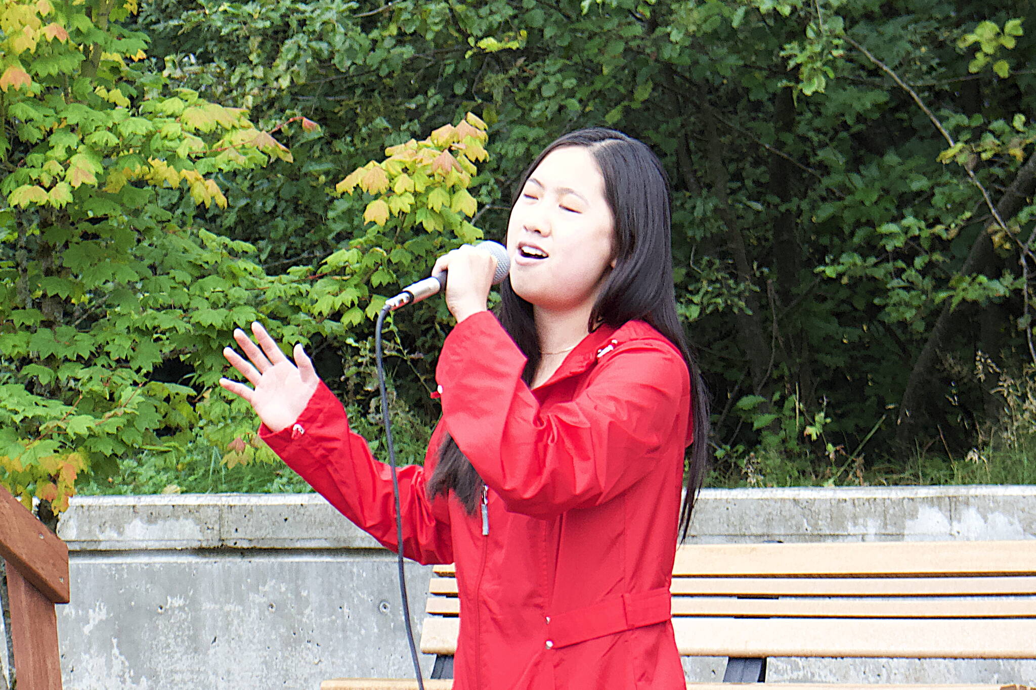 Elizabeth Djajalie sings the national anthem during a ceremony Monday at the September 11th Memorial at Riverside Rotary Park commemorating the terrorist attacks on that date in 2001. (Mark Sabbatini / Juneau Empire)