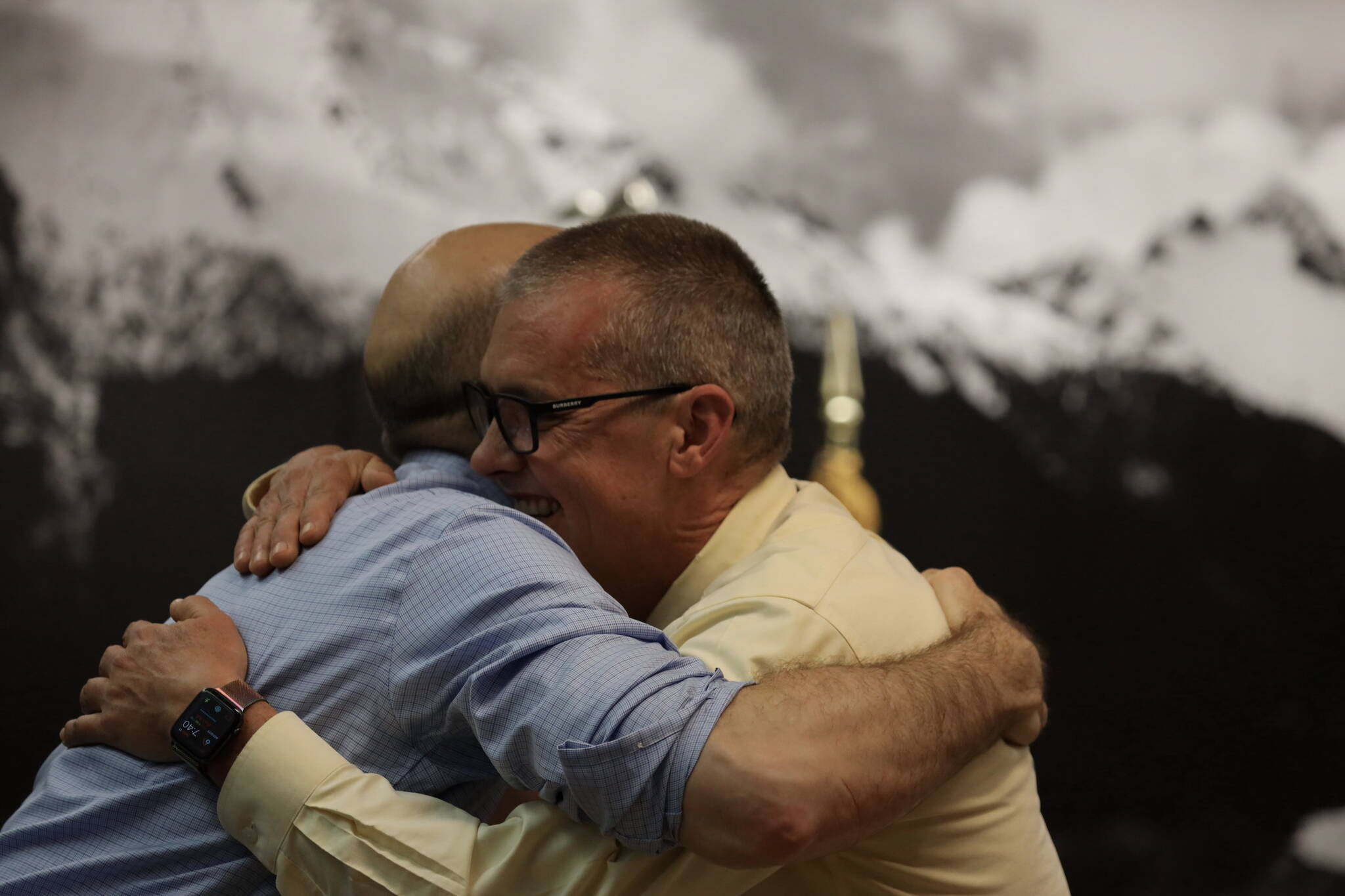 City and Borough of Juneau Deputy City Manager Robert Barr (left) and retiring City Manager Rorie Watt (right) hug Monday night during an Assembly meeting where Watt was honored for his time as manager. (Clarise Larson / Juneau Empire)