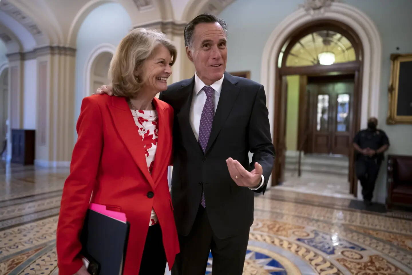 U.S. Sens. Lisa Murkowski and Mitt Romney greet each other outside the chamber at the U.S. Capitol on April 5, 2022. (J. Scott Applewhite / AP file photo)
