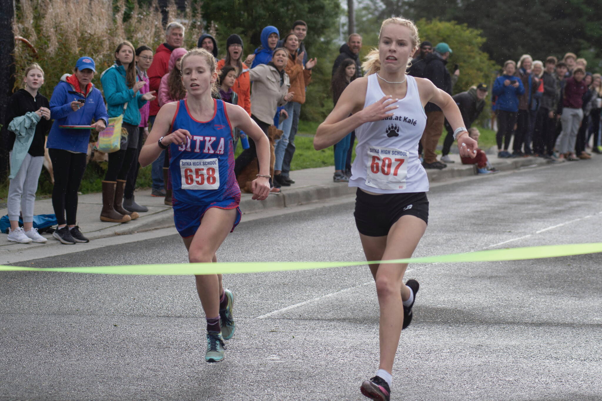 Juneau-Douglas High School: Yadaa.at Kalé junior Ida Meyer, right, wins the Sitka Invitational by a fraction of a second in front of Sitka junior Clare Mullin on Saturday. (James Poulson / Sitka Sentinel)