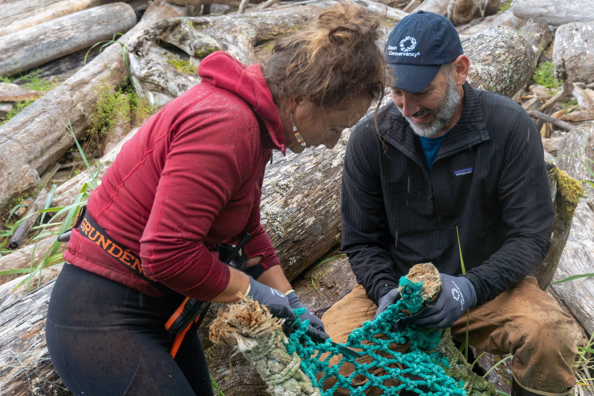Zofia Danielson, marine debris coordinator with Sitka Sound Science Center, works alongside Michael LaVine, senior director of Alaska programs with Ocean Conservancy, to portion up a large piece of trawl net to be carried back to the pickup site. (Ryan Morse / Sitka Conservation Society)