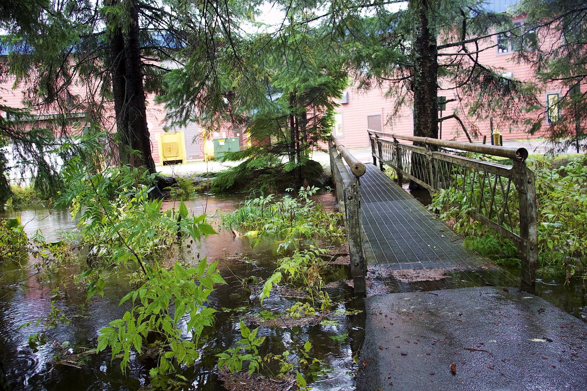 Jordan Creek flows over a portion of a footbridge behind a shopping center Thursday evening. The National Weather Service has issued a flood warning for Jordan Creek, Montana Creek and Auke Lake until 10 a.m. Friday. (Mark Sabbatini / Juneau Empire)