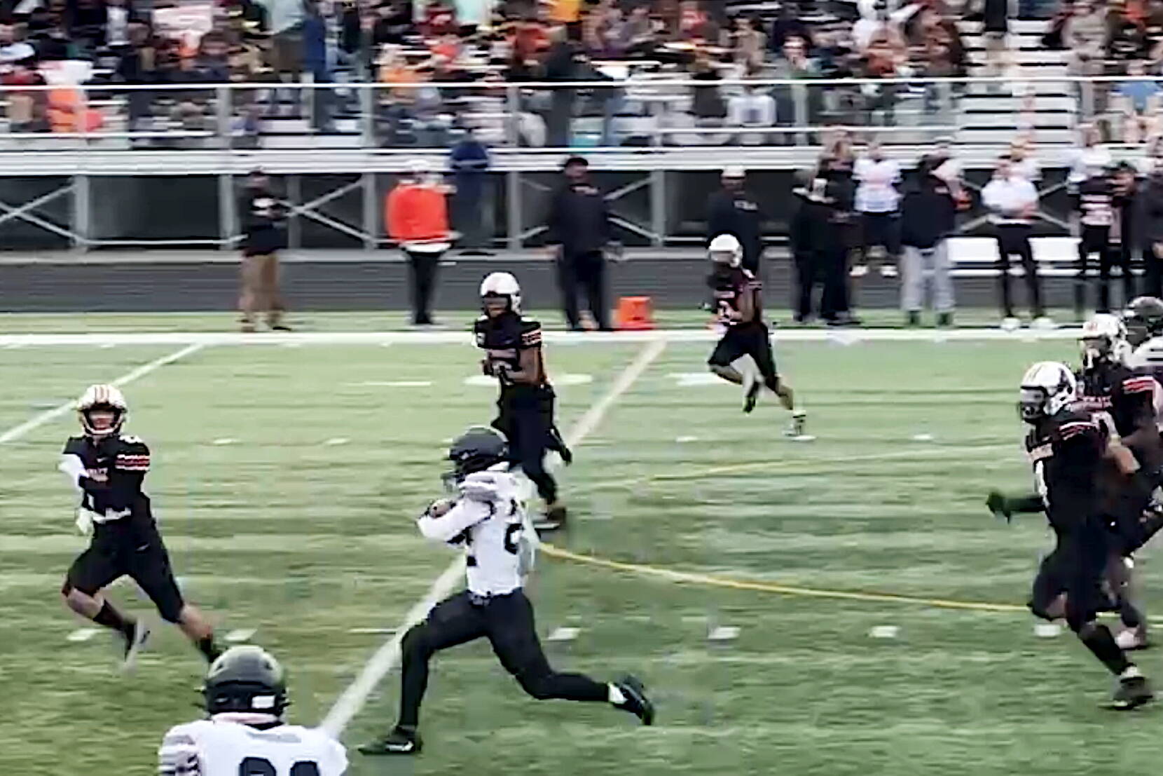 Juneau’s Anthony Garcia (22) carries the ball deep into West Anchorage High School territory to set up the Huskies’ first touchdown early in the third quarter during Saturday’s game in Anchorage. (Screenshot from Juneau Huskies football livestream video)