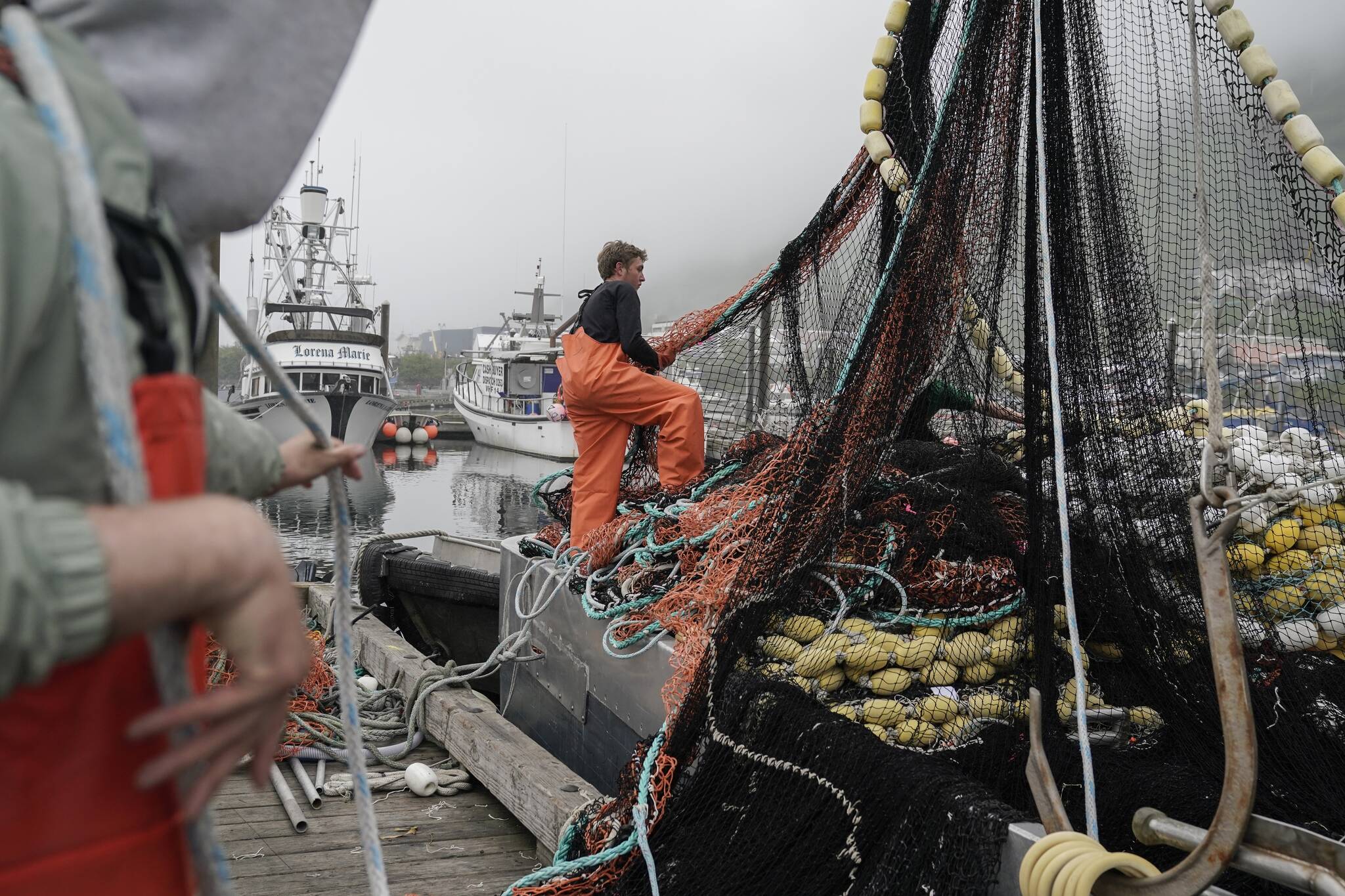 Deckhands stack nets on a boat before heading out to sea to fish salmon, Thursday, June 22, 2023, in Kodiak, Alaska. (AP Photo/Joshua A. Bickel)