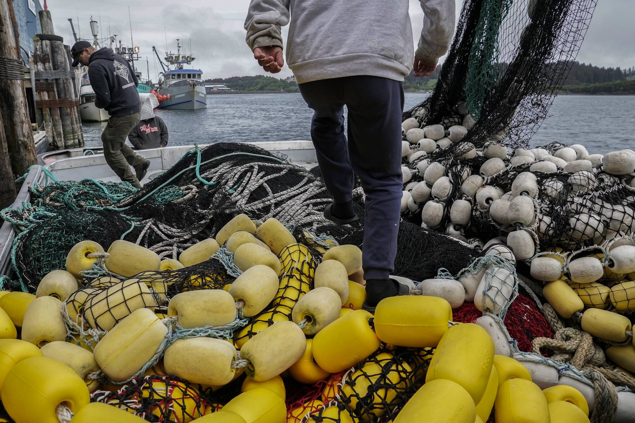 Darren Platt, left, captain of the Agnes Sabine, and first-year deckhand Juan Zuniga, right, step over nets as they dock the boat for refueling, Friday, June 23, 2023, in Kodiak, Alaska. Retaining deckhands is key for Platt and he says he focuses on keeping crew members as comfortable as possible so that they might return again to work the following season while teaching them the skills they need to perform their job on the boat. (AP Photo/Joshua A. Bickel)