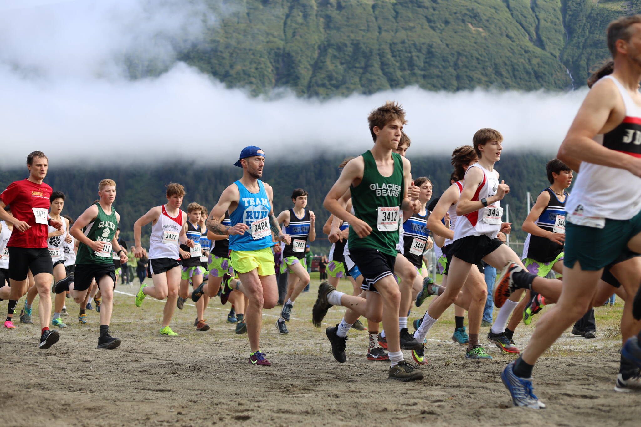 High school boys sprint after the starting gun fires during the Sayeik Invitational on Douglas on Aug. 26. Students from Southeast Alaska schools are scheduled to meet at the same site Saturday for the Region V cross-country champions. (Clarise Larson / Juneau Empire File)
