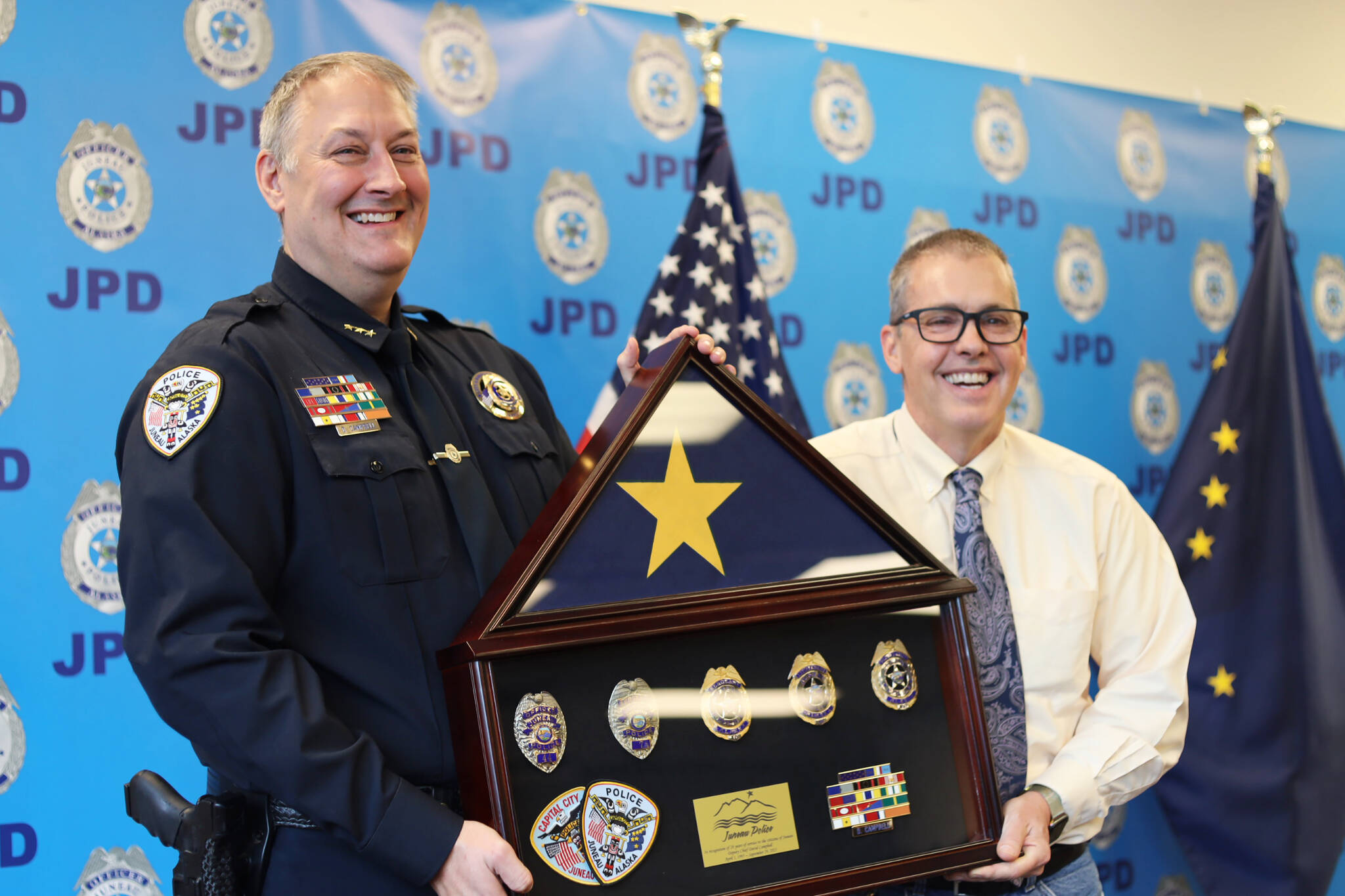 Retiring Deputy Chief David Campbell, left, and City and Borough of Juneau Manager Rorie Watt, right, smile for a photo Friday afternoon during a ceremony held at the Juneau Police Station. (Clarise Larson / Juneau Empire)