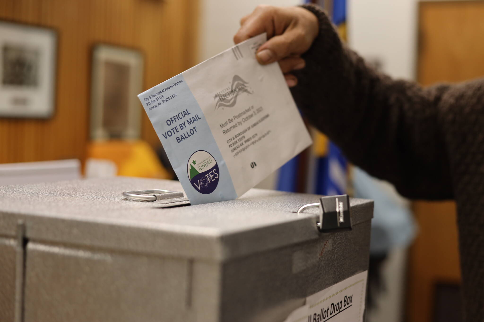 Michael Beasley drops a ballot into a drop box at the City Hall Assembly Chambers on Election Day Tuesday morning. (Clarise Larson / Juneau Empire)