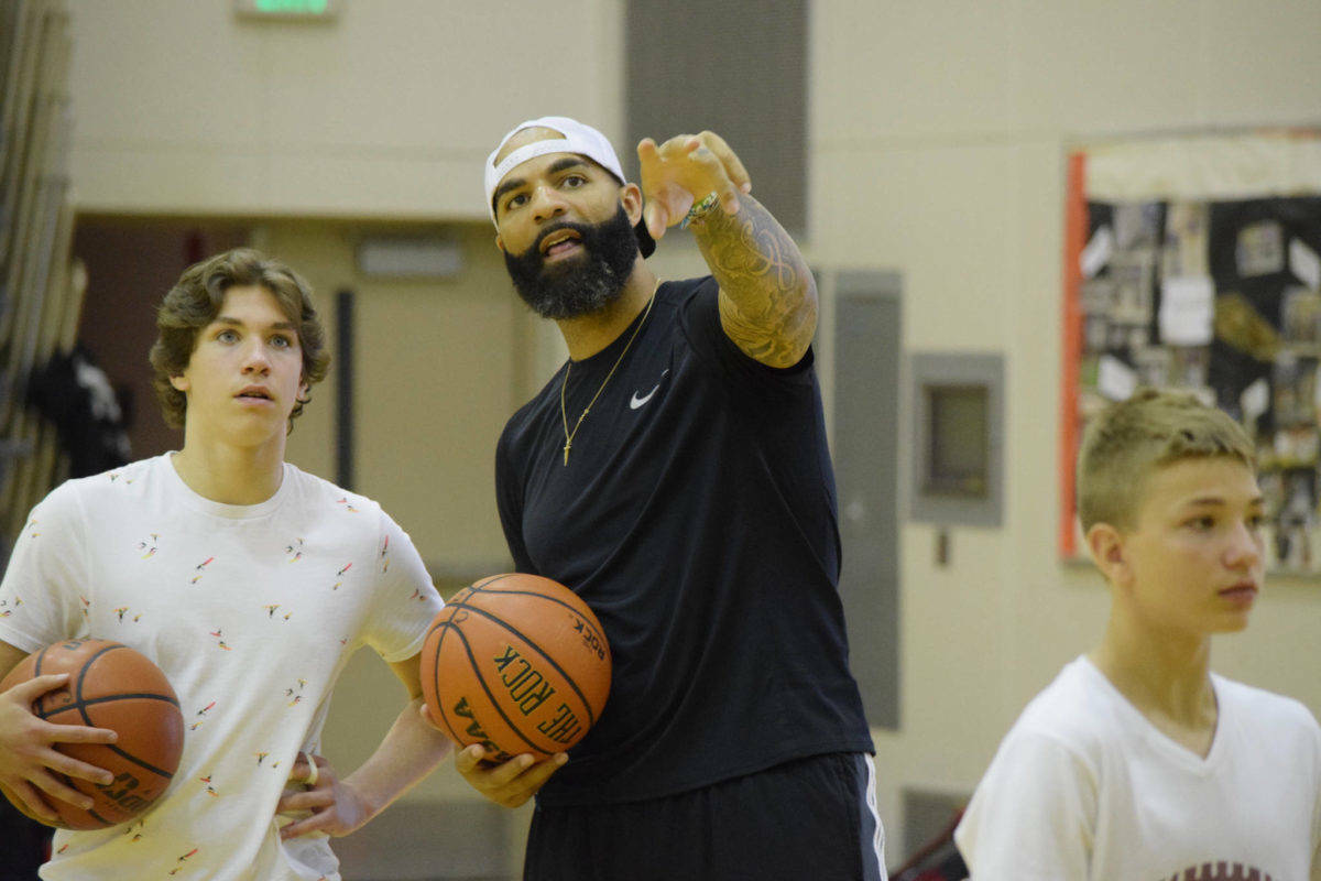 Carlos Boozer, a former Juneau high school basketball player and retired NBA all-star, talks with a student at his basketball camp in Juneau in 2017. (Nolin Ainsworth/Juneau Empire File)
