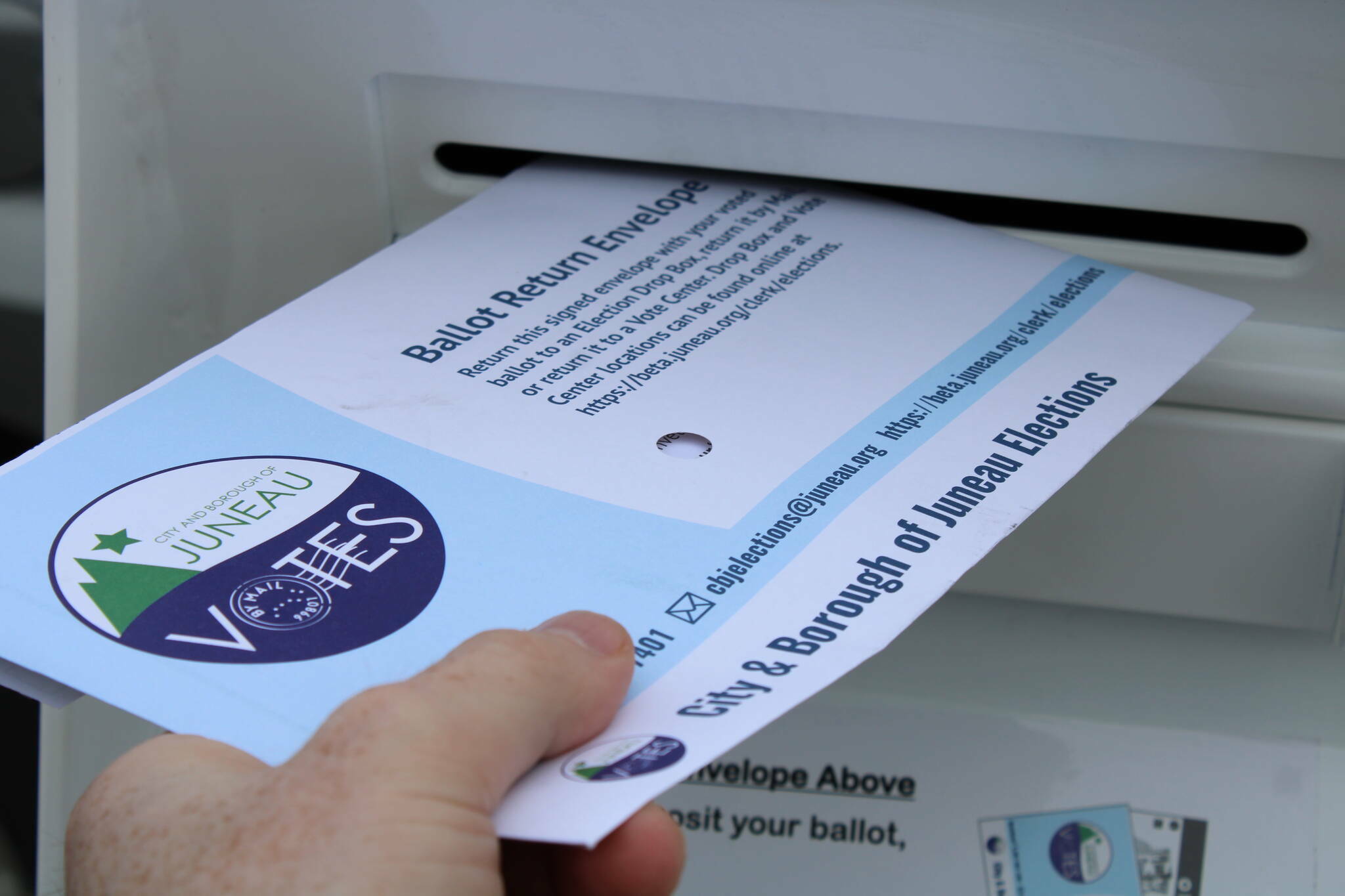 A local-mail in ballot is deposited in a drop box. (Ben Hohenstatt / Juneau Empire File)