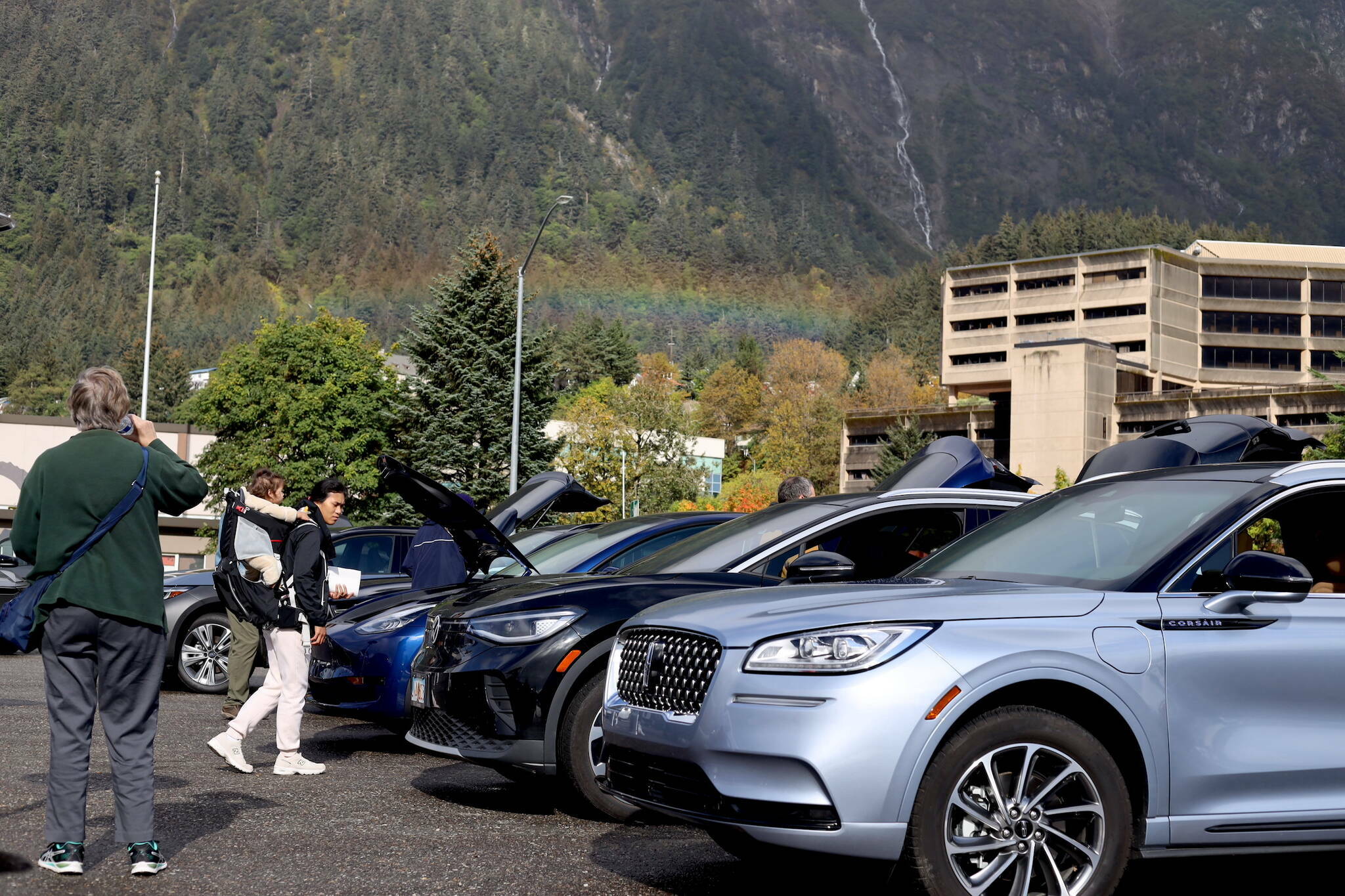 A rainbow appears over downtown as residents check out rows of electric vehicles at Juneau’s EV & E-bike Roundup on Sept. 23. (Clarise Larson / Juneau Empire File)