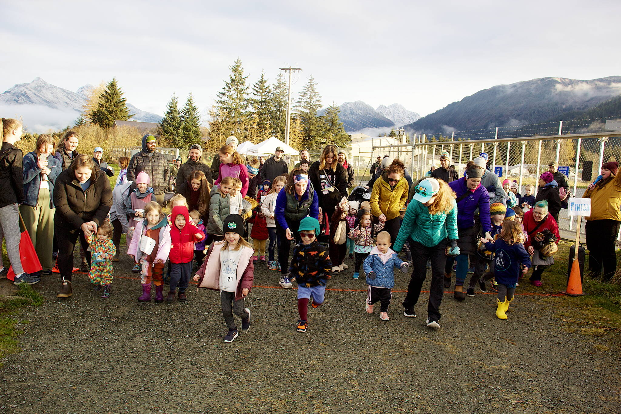 Youngsters, some accompanied by their parents, dash out from the starting line of the 80-yard Toddler Trot as part of the second annual Real Talk Walk/Run on Saturday at the Airport Dike Trail. (Mark Sabbatini / Juneau Empire)