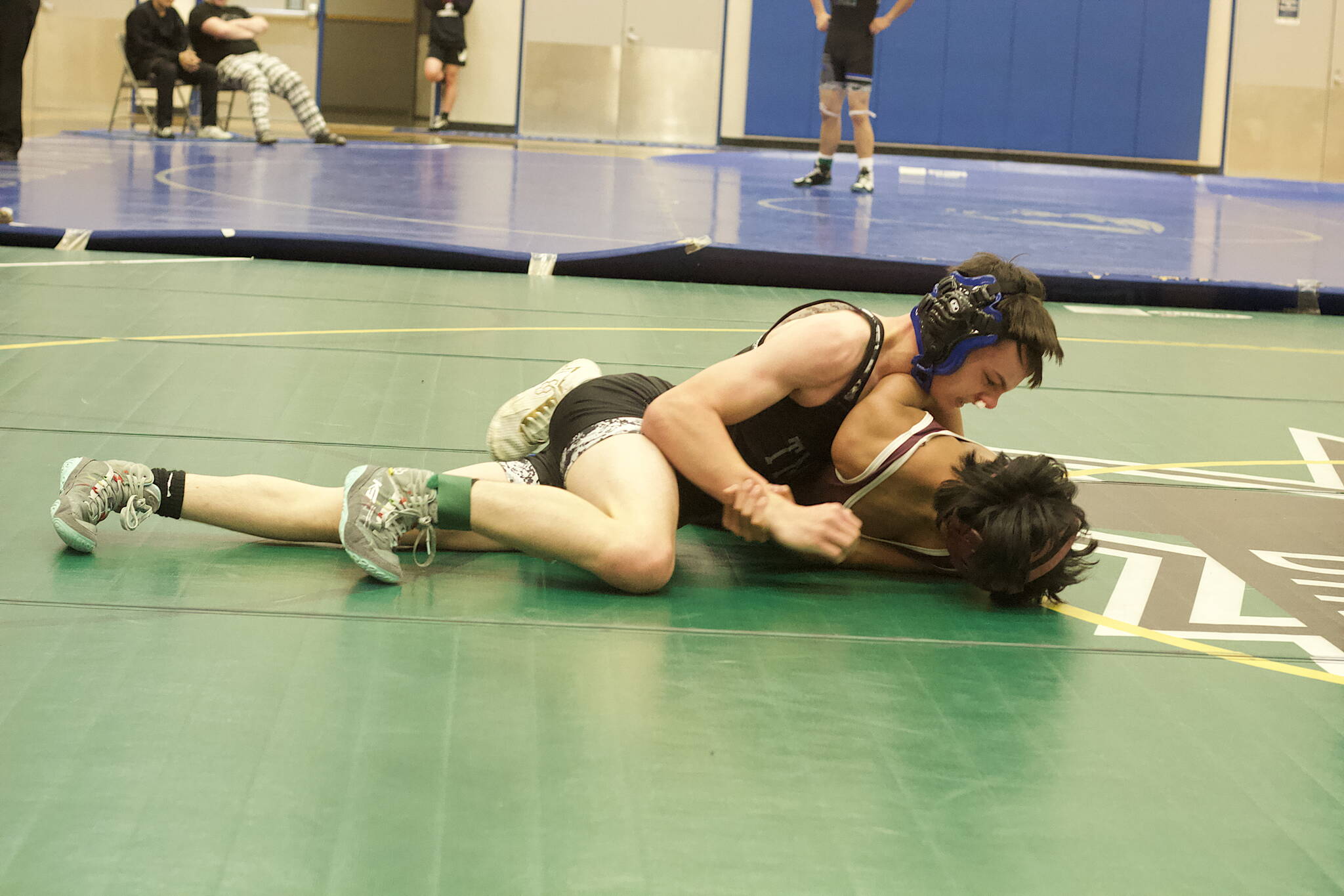 Gavin Holt of Thunder Mountain High School, top, tries to pin RJ Cadiente of Ketchikan High School in their third-place match in the Southeast Showdown at TMHS on Saturday. Cadiente won the match to claim third place in the 112-pound division. (Mark Sabbatini / Juneau Empire)
