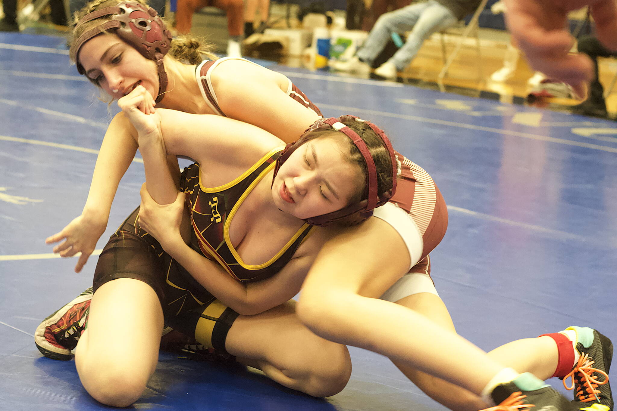 Meg Thompson of Ketchikan High School, top, and Hayden Nanang of Mt. Edgecumbe High School battle to make the final rounds of the Southeast Showdown at Thunder Mountain High School on Saturday. Thompson finished second and Nanang third in the girls 114-pound division. (Mark Sabbatini / Juneau Empire)