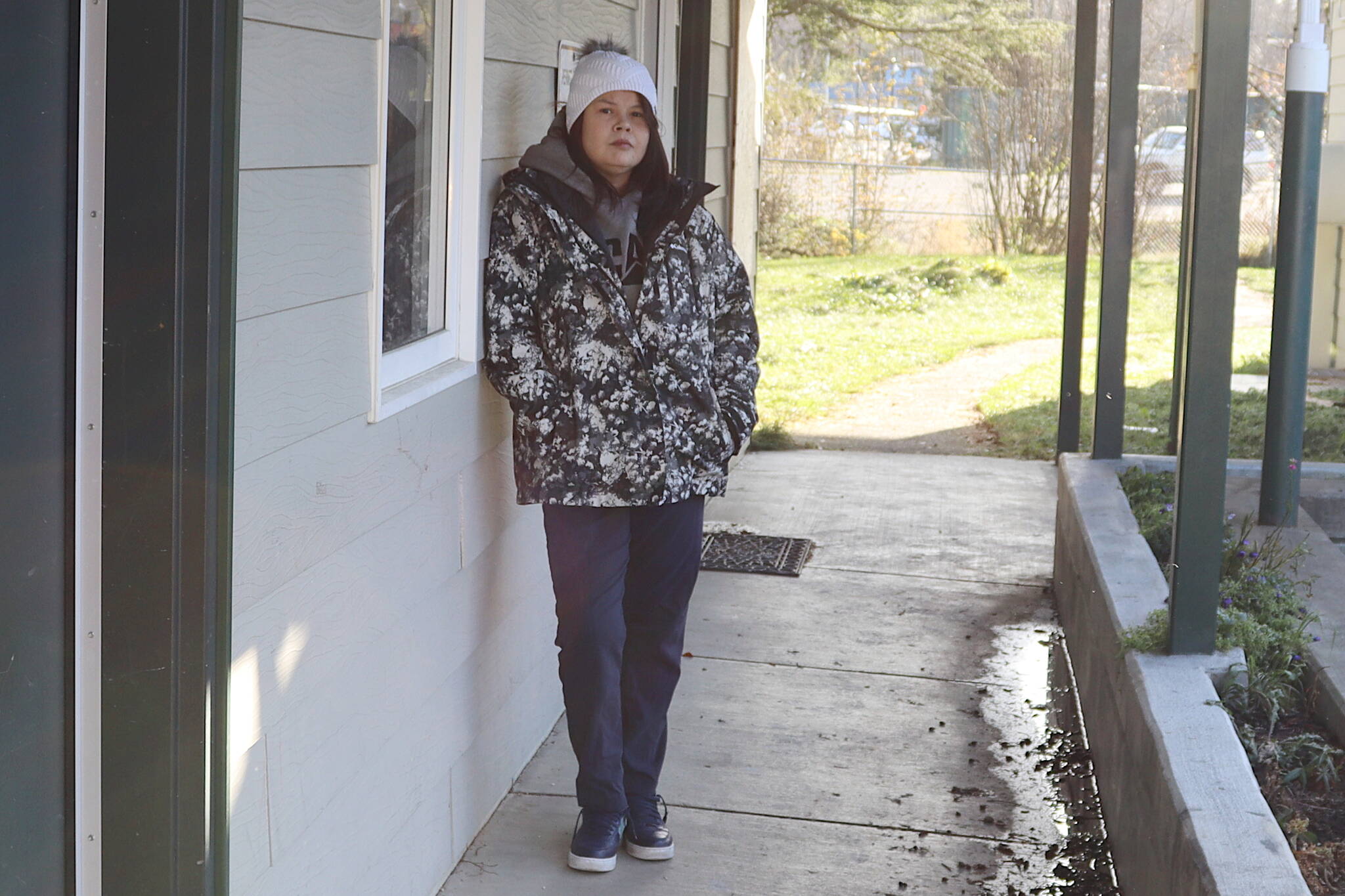 Kaley Nauska stands outside her smoke-damaged apartment on Monday, a day after a fire at her next-door neighbor’s apartment. (Meredith Jordan / Juneau Empire)