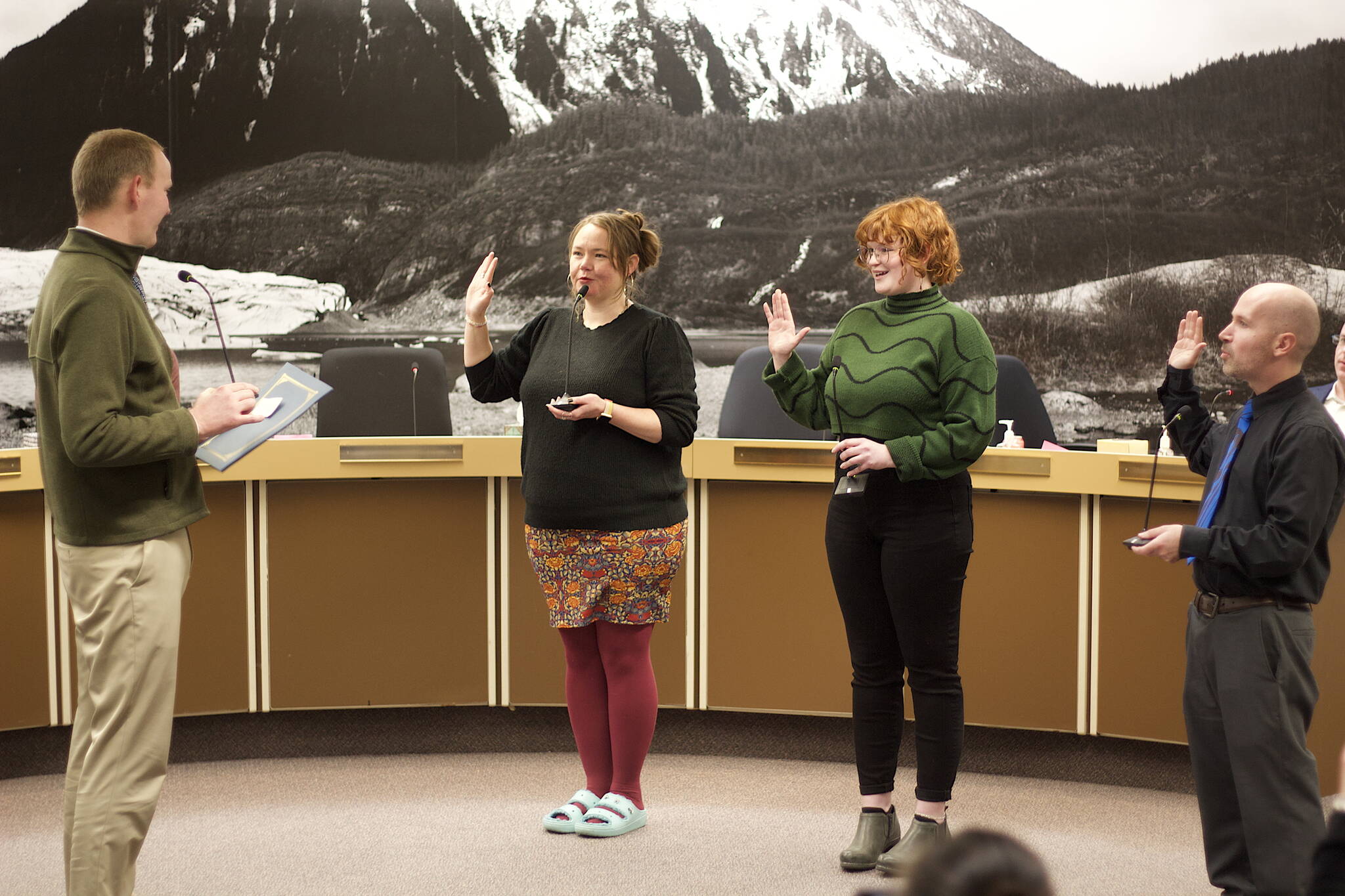 Juneau City and Borough Attorney Robert Palmer, left, swears in Assembly members Alicia Hughes-Skandijs, Ella Adkison and Paul Kelly on Monday night in the Assembly chambers. Adkison and Kelly are new members of the Assembly after winning open seats in the Oct. 3 municipal election, while incumbents Hughes-Skandijs and Christine Woll — who was sworn in remotely via Zoom at the same time — were reelected to their seats. (Mark Sabbatini / Juneau Empire)