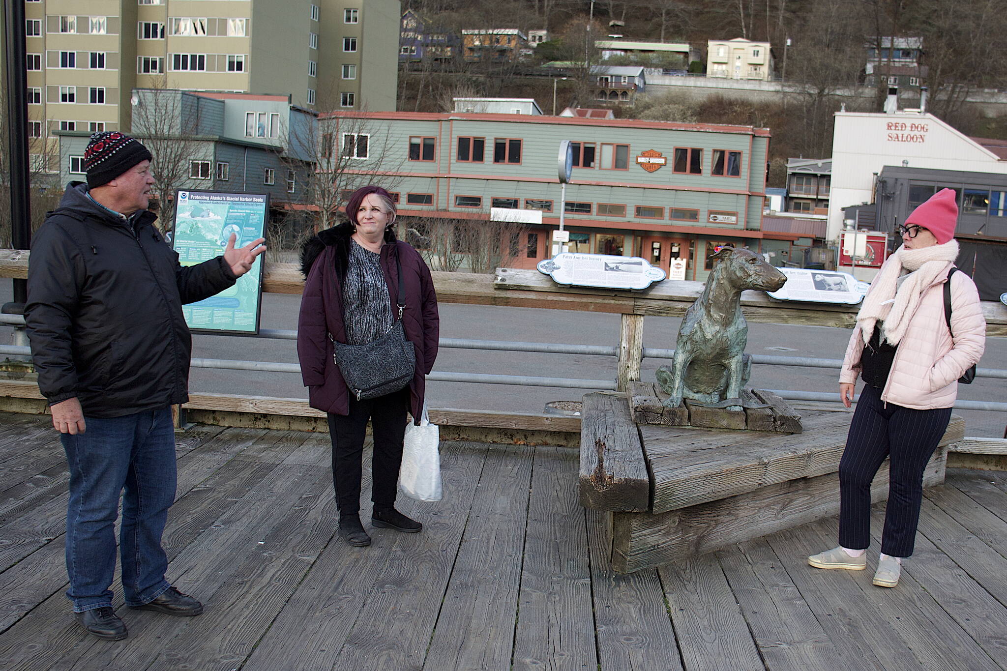 George Lacek (left), Diane Edwards (middle) and LaDele Sines discuss how they spent the last day of the cruise ship season near the Patsy Ann statue next to their ship Wednesday evening. (Mark Sabbatini / Juneau Empire)