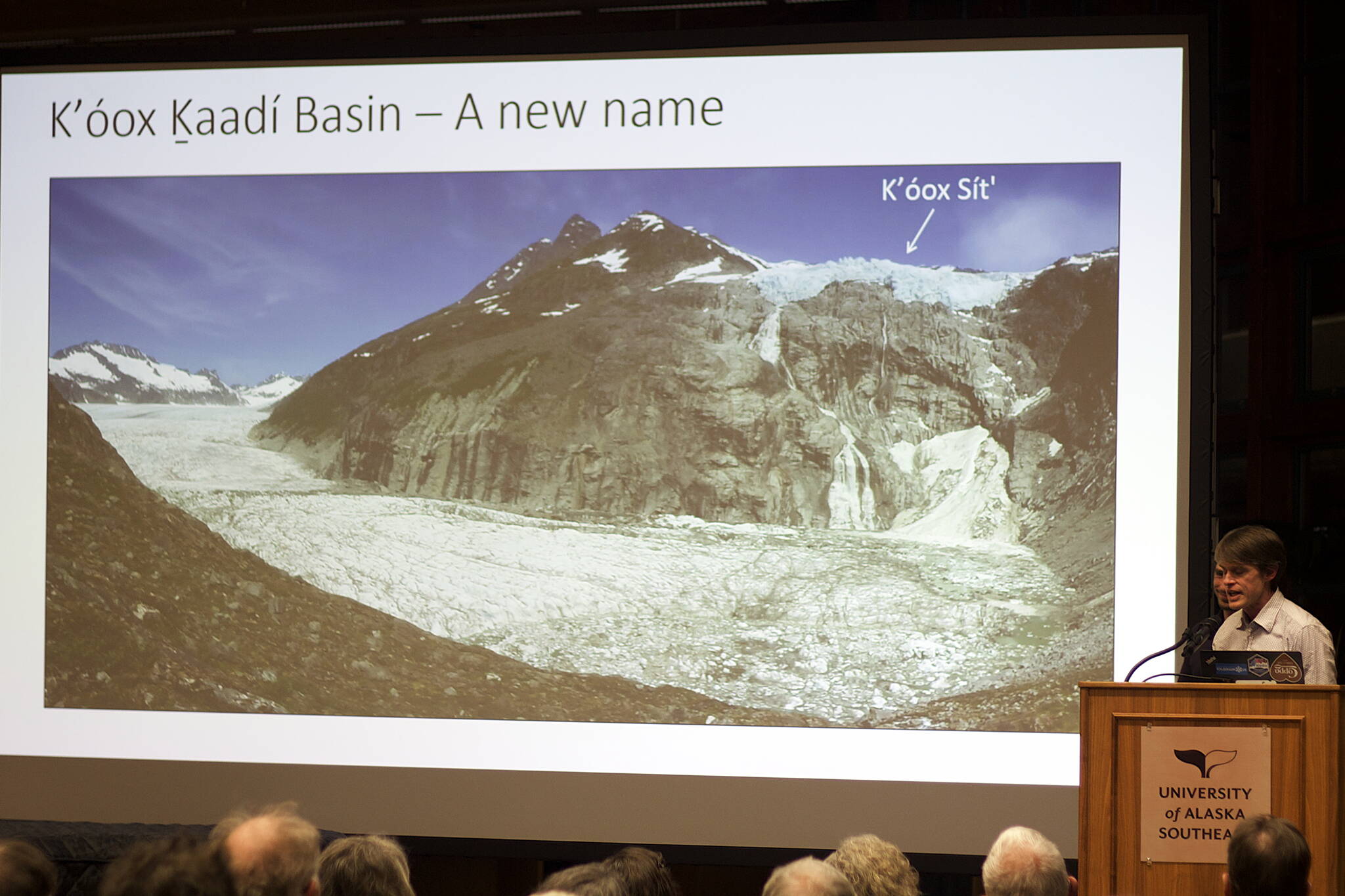 University of Alaska environmental science professor Eran Hood (foreground right) and National Weather Service Juneau hydrologist Aaron Jacobs discuss their hope of renaming Suicide Basin to Kʼóox Ḵaadí Basin, a Tlingit name referring to a small weasel-like mammal in the area — during a presentation Friday at the University of Alaska Southeast. They also discussed the basin’s history, a record flood from it that occurred this summer and the possibility of future such floods. (Mark Sabbatini / Juneau Empire)