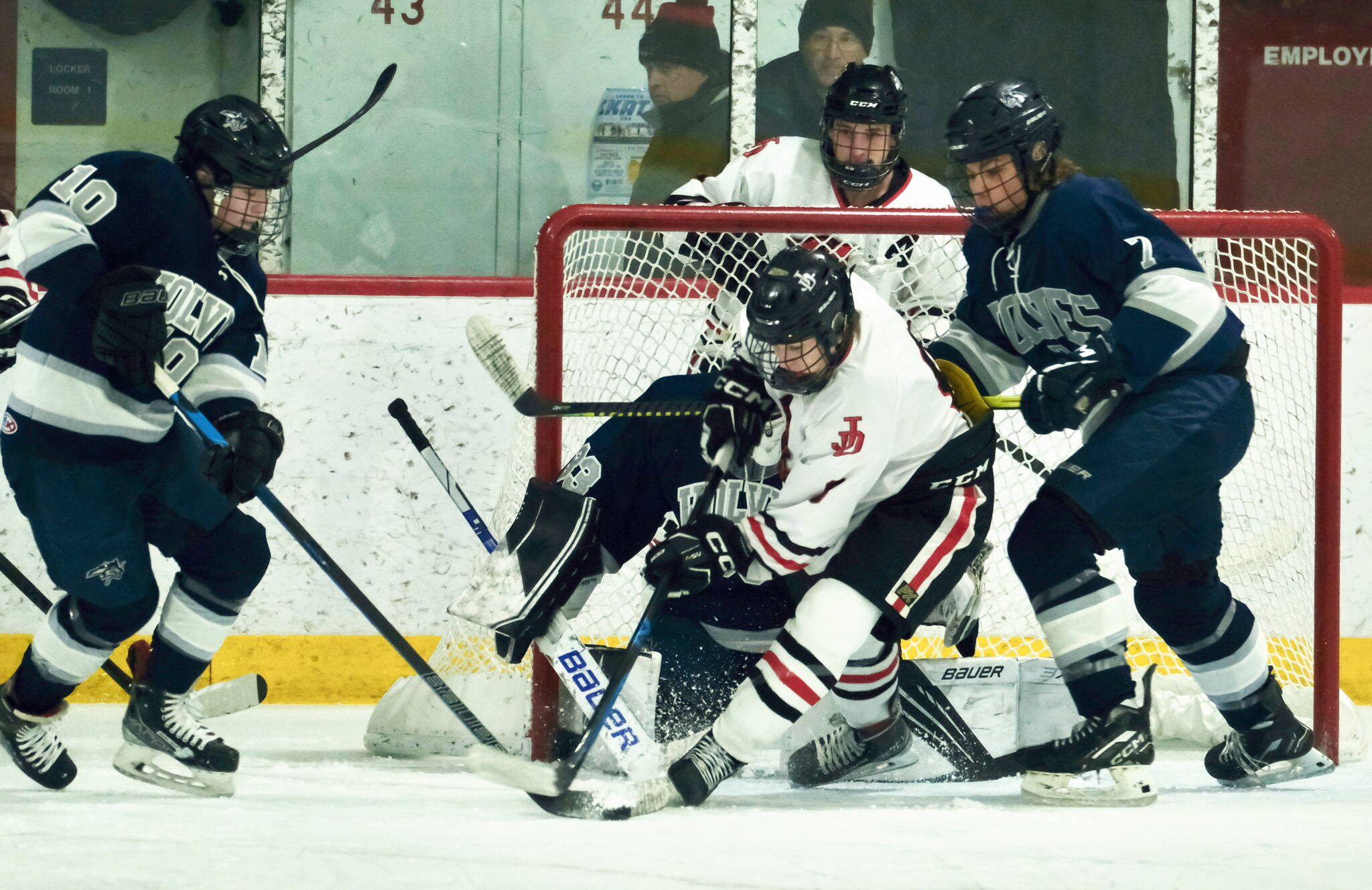 Juneau-Douglas High School: Yadaa.at Kalé junior Alexander Smith battles for a puck in front of the Eagle River goal during Saturday’s 6-1 Crimson Bears win over the Wolves at Treadwell Arena. (Klas Stolpe for the Juneau Empire)