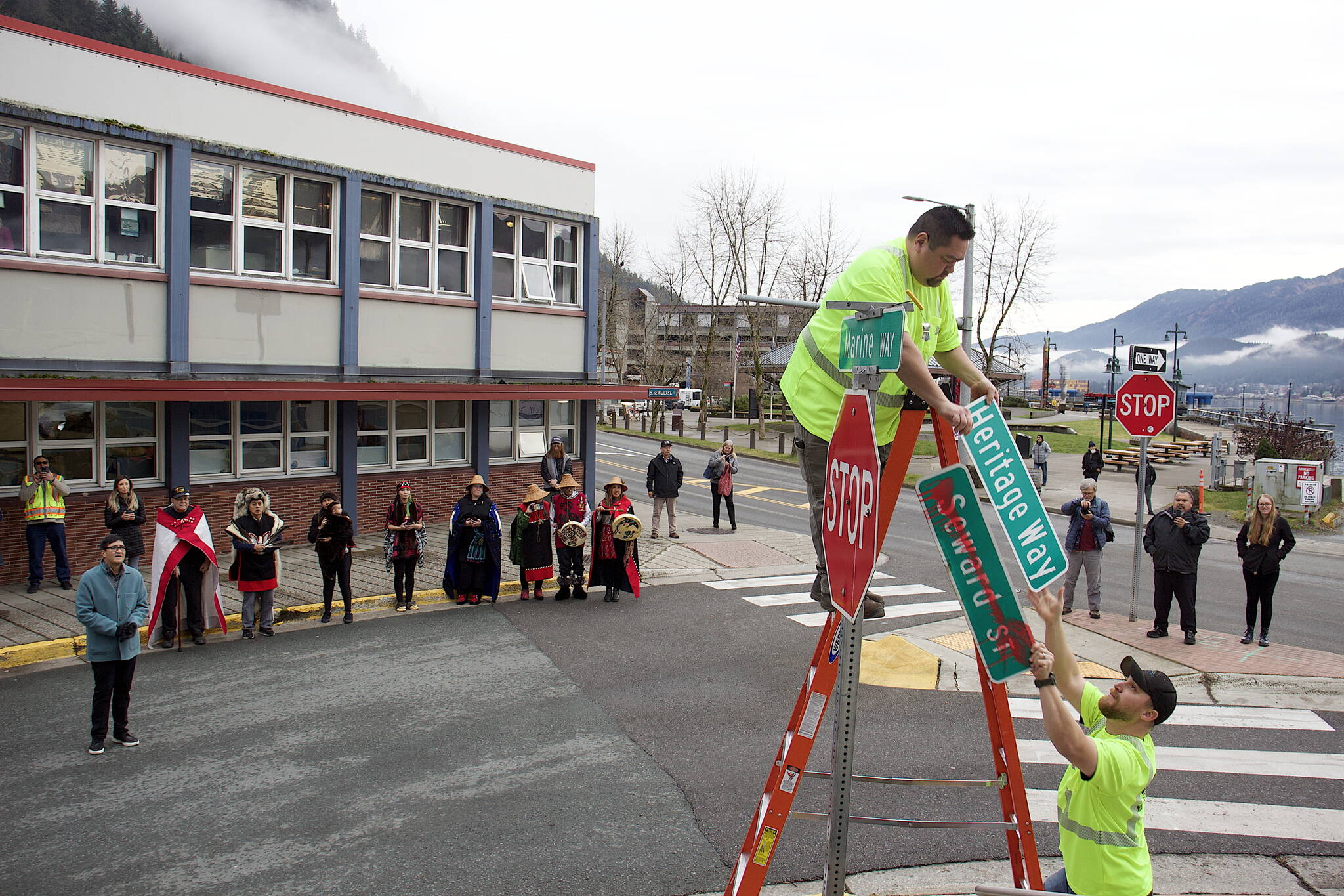 Randal Jim (center) and Joey Ludlam replace a “Seward St.” with a “Heritage Way” sign at midday Wednesday, the day the new name became official for a two-block portion of the downtown street. About 50 local tribal leaders, city officials and others attended a ceremony at Sealaska Plaza marking the name change effort that originated in April. (Mark Sabbatini / Juneau Empire)