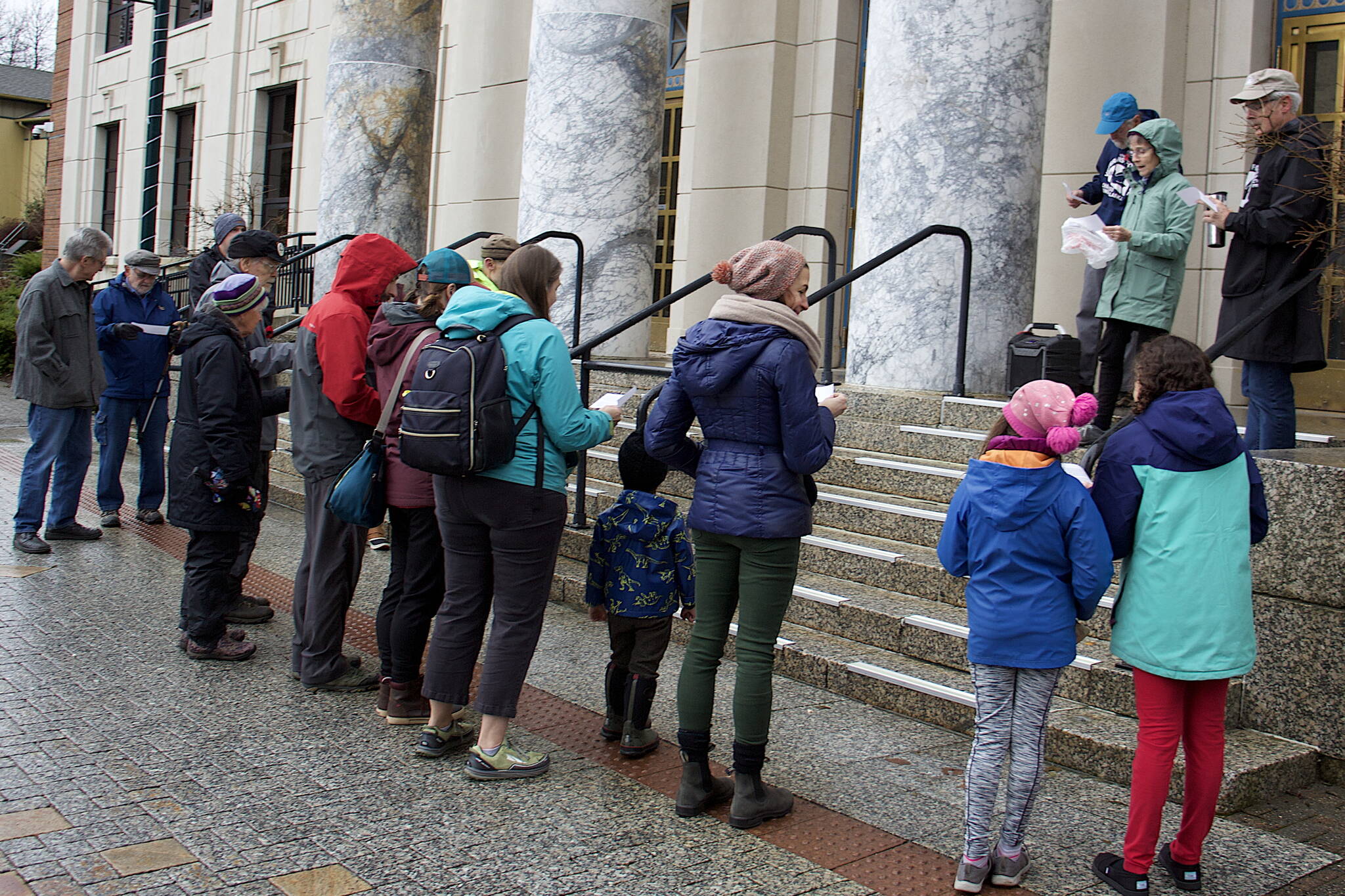 About 15 people sing on the steps of the Alaska State Capitol during an Armistice Day observation on Saturday hosted by Juneau Veterans for Peace. (Mark Sabbatini / Juneau Empire)