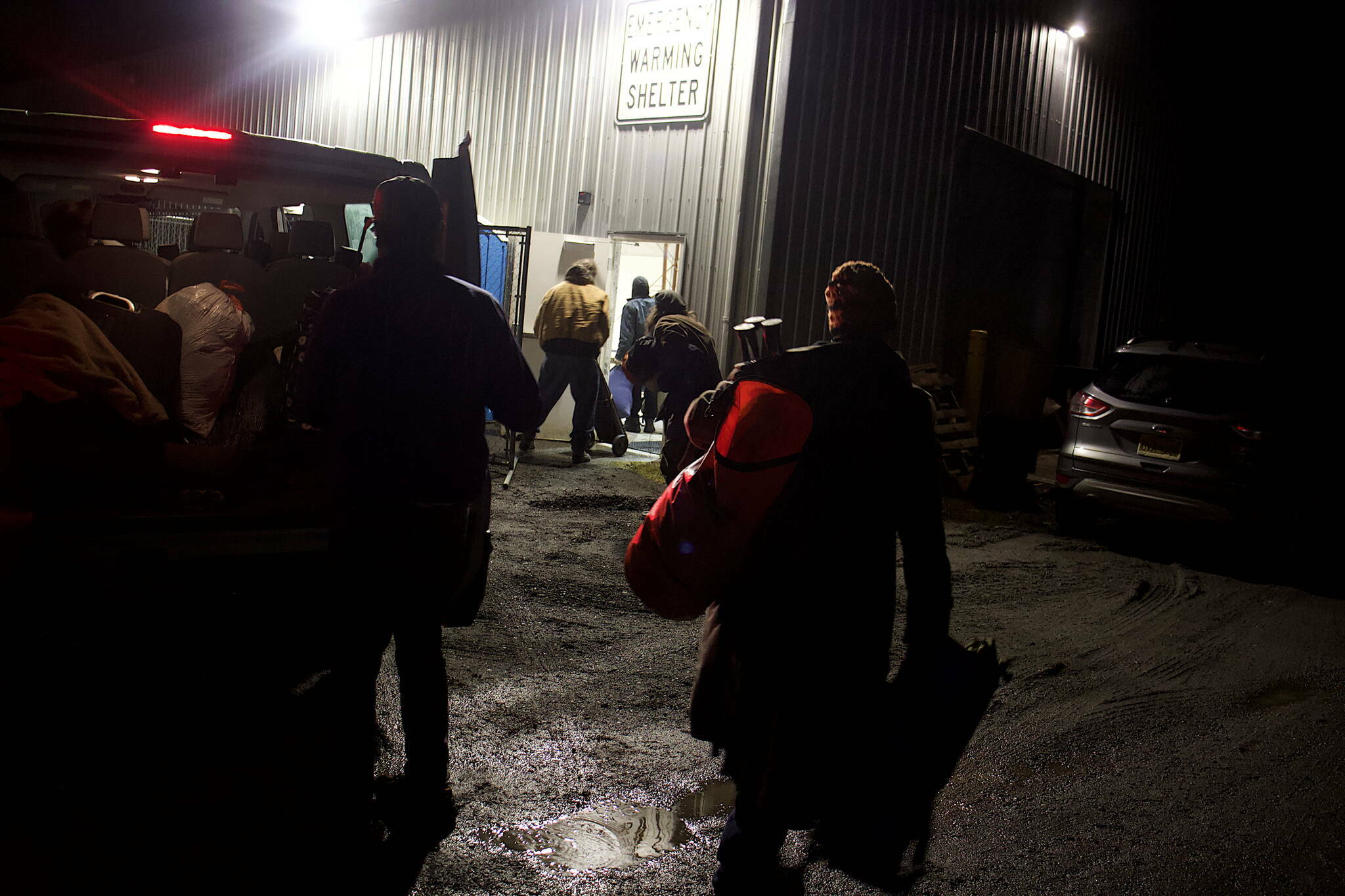 People arriving on a shuttle bus enter the city’s new cold weather emergency shelter on Oct. 20, the first night it was open. (Mark Sabbatini / Juneau Empire File)