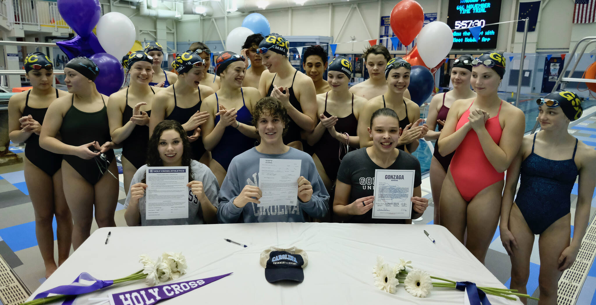 Juneau-Douglas High School: Yadaa.at Kalé senior Samantha Schwarting and Thunder Mountain High School seniors PJ Foy and Olivia Mills (shown with Glacier Swim Club teammates) hold their signed National Letters of Intent (NLI) on Tuesday at the Dimond Park Aquatic Center. (Klas Stolpe for the Juneau Empire)