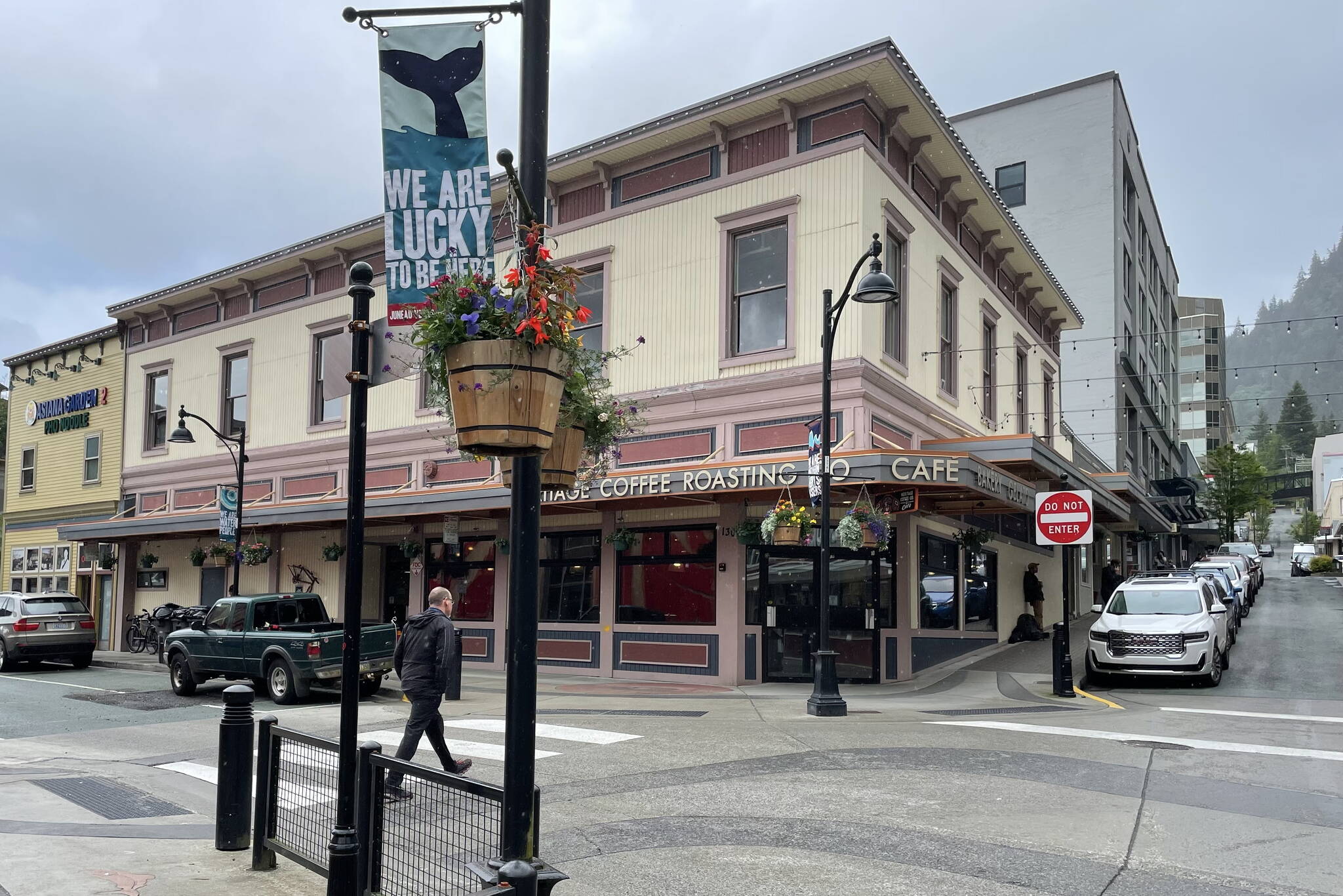 The 125-year-old building at the corner of Front and Seward as seen in summer of 2023. Juneau moved utilities underground and upgraded street lights in the mid-1980s and again recently. Each summer different sayings are displayed on colorful banners (“We are lucky to live here” on this banner) and flower baskets, bringing lively attention to downtown. (Photo by Laurie Craig)