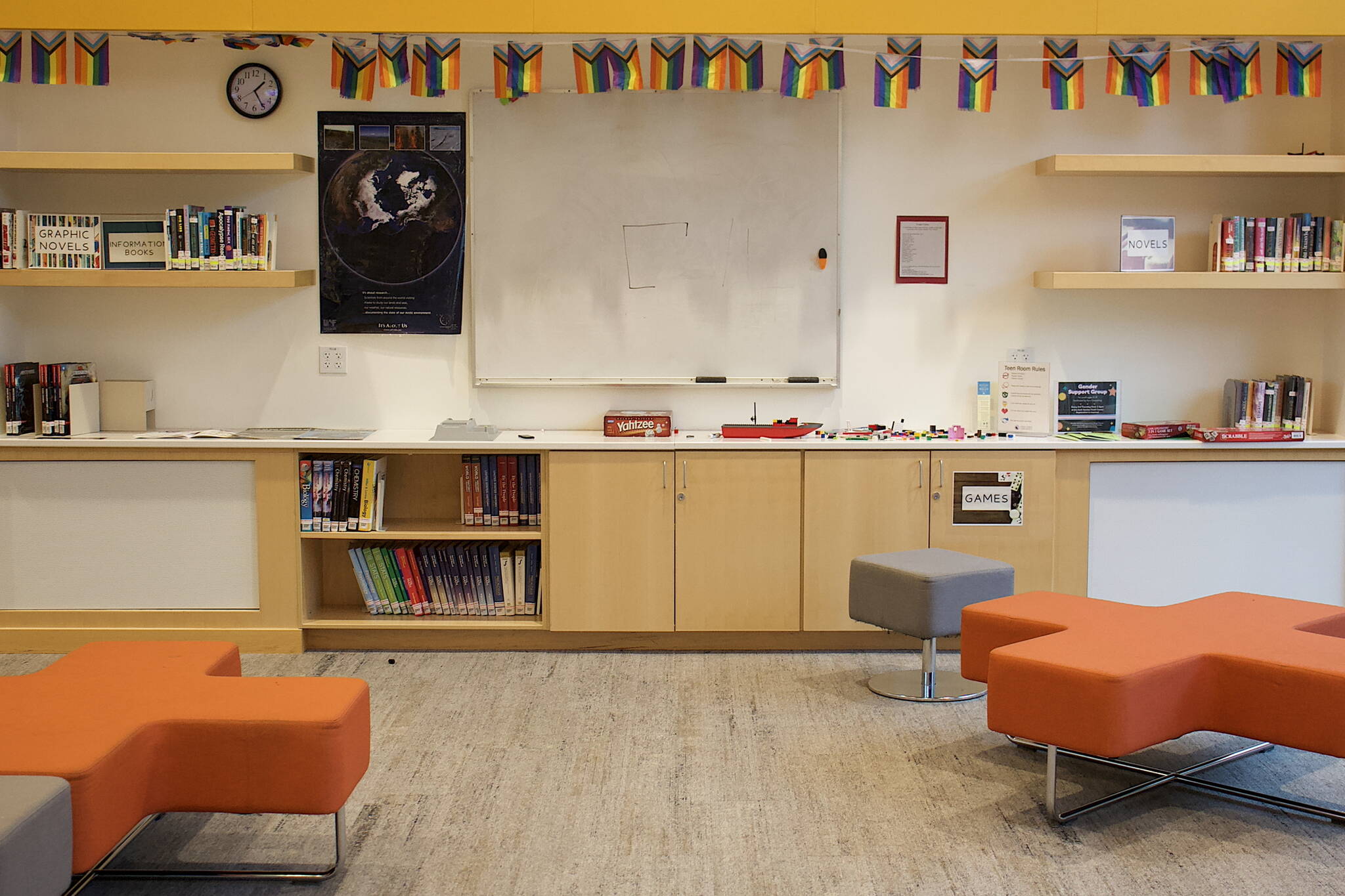 A row of rainbow flags are displayed above the bookshelves in the teen room at the Mendenhall Valley Public Library. (Mark Sabbatini / Juneau Empire)