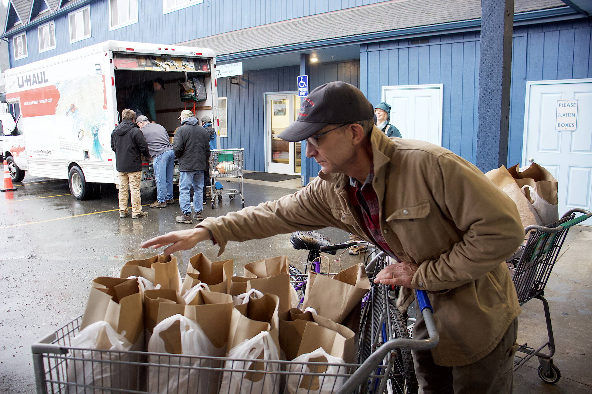 Joe Pagenkopf counts bags of food in a shopping cart at the St. Vincent de Paul Juneau complex on Saturday morning before heading out to deliver Thanksgiving food baskets to local residents. He said it is his first time making such deliveries, which he was motivated to get after getting help when his home was nearly destroyed by the record flooding of Suicide Basin earlier this year. (Mark Sabbatini / Juneau Empire)